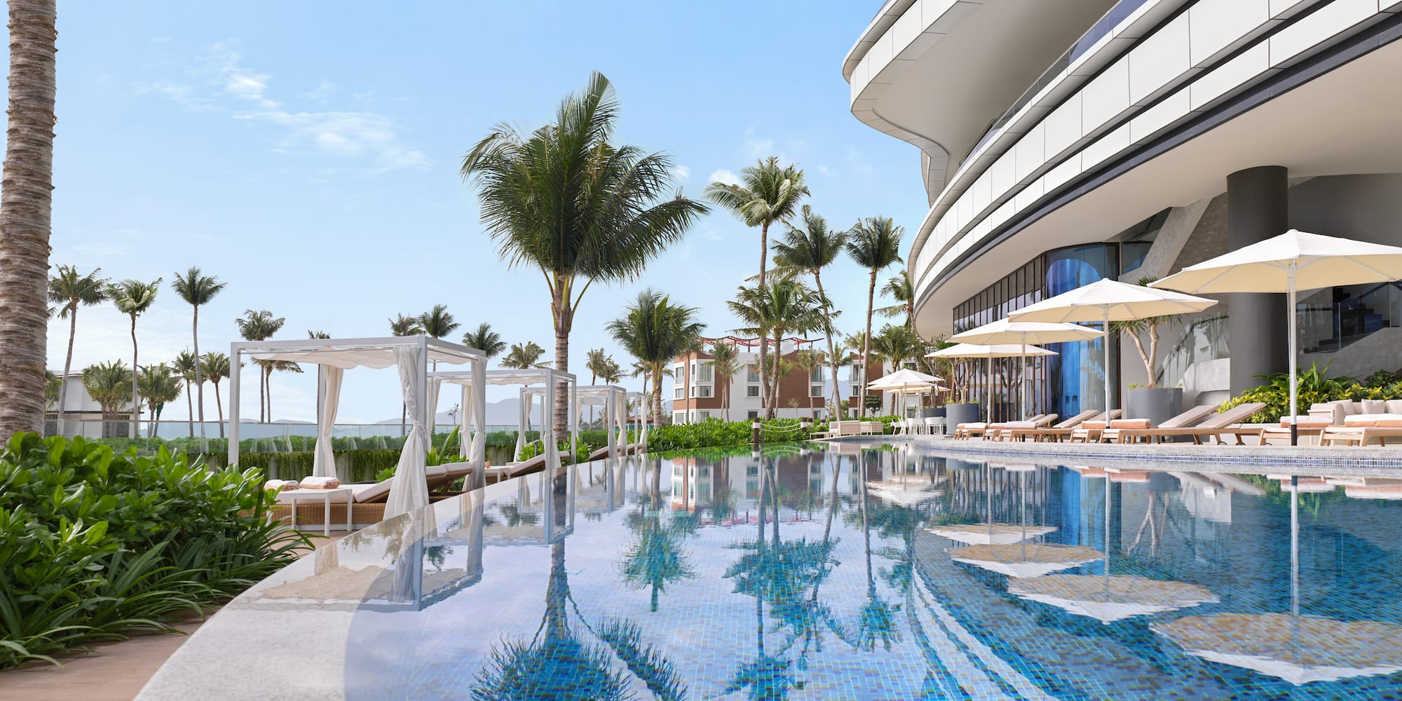 a pool with palm trees and a building