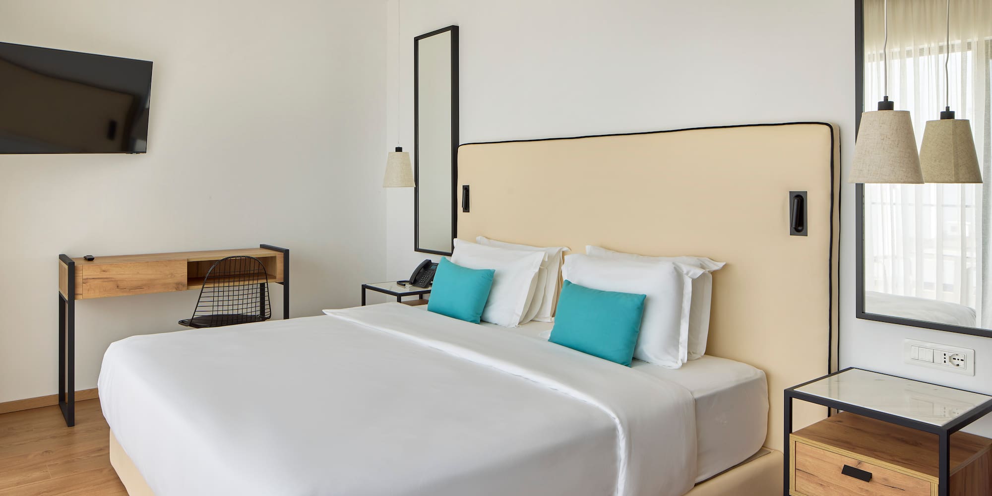 a bed with white sheets and blue pillows