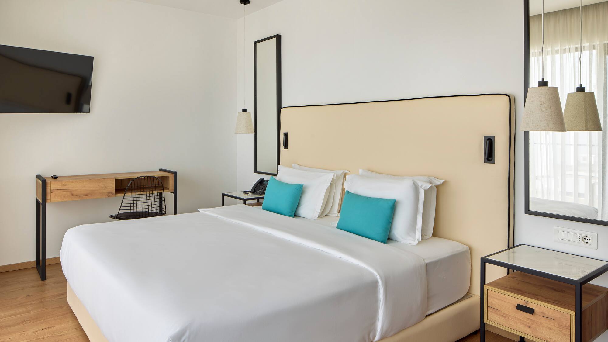 a bed with white sheets and blue pillows