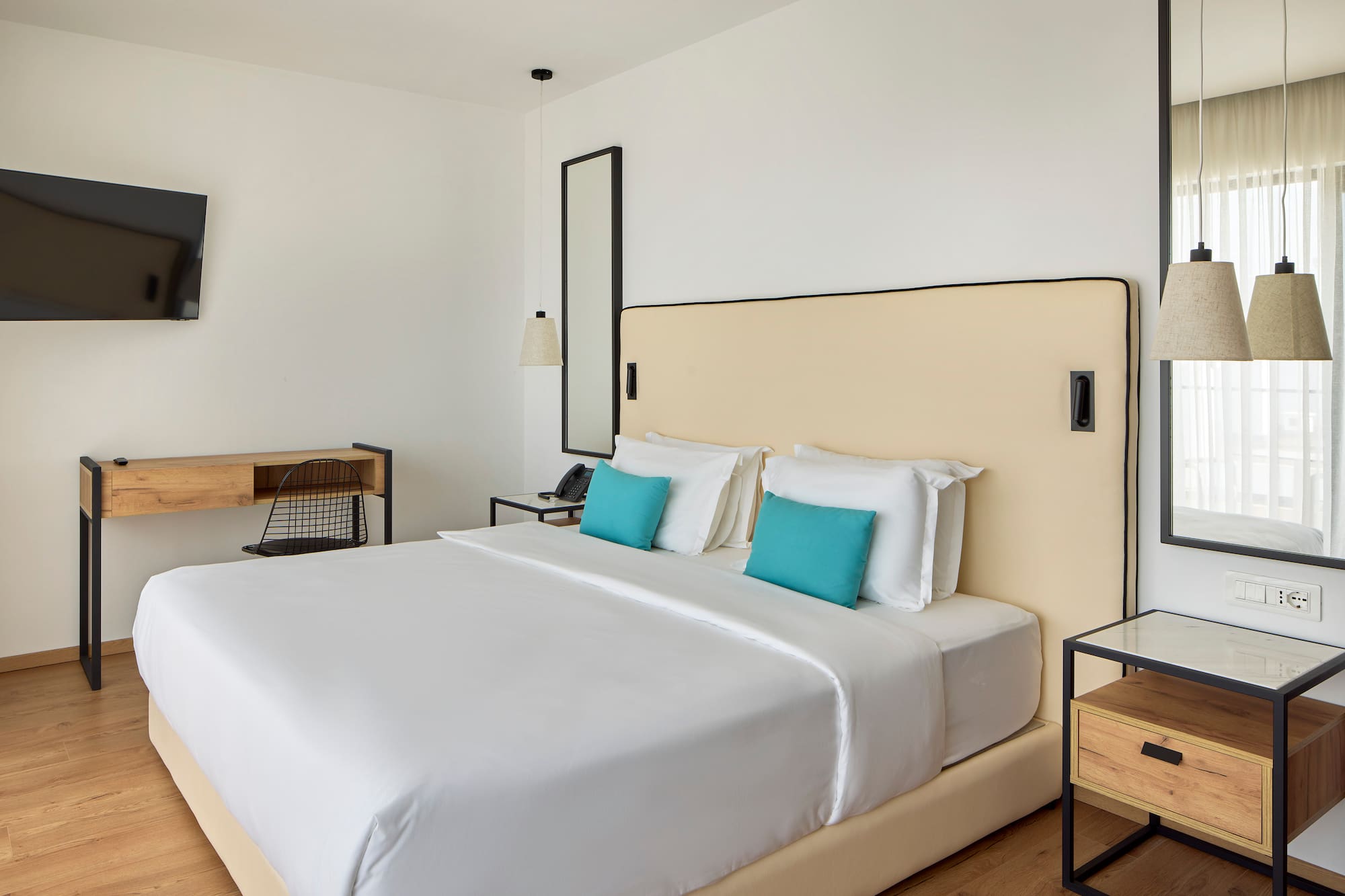 a bed with white sheets and blue pillows