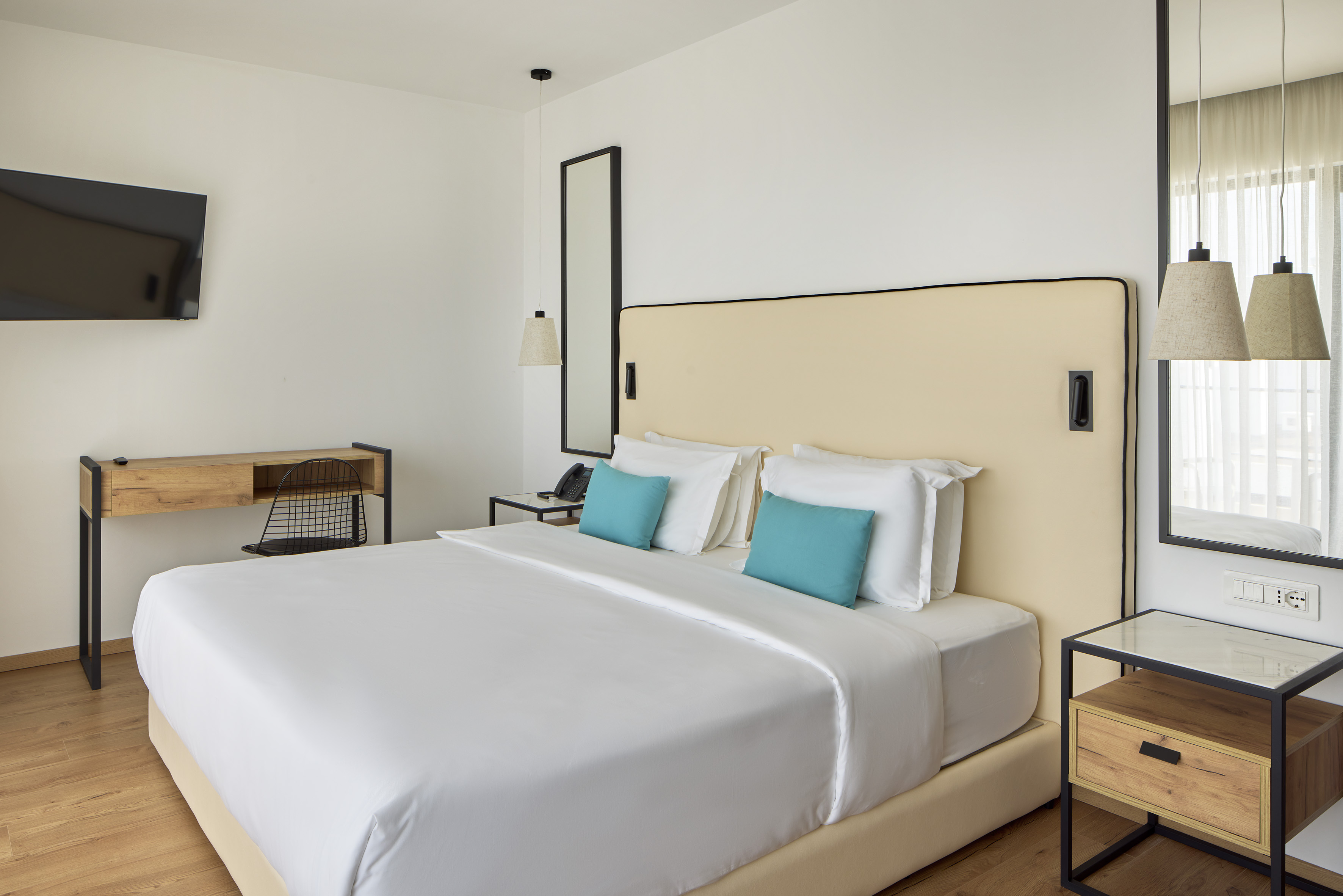 a bed with white sheets and blue pillows