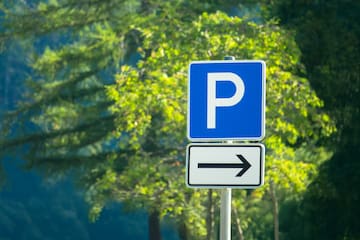 a blue and white sign with a white arrow pointing to the left