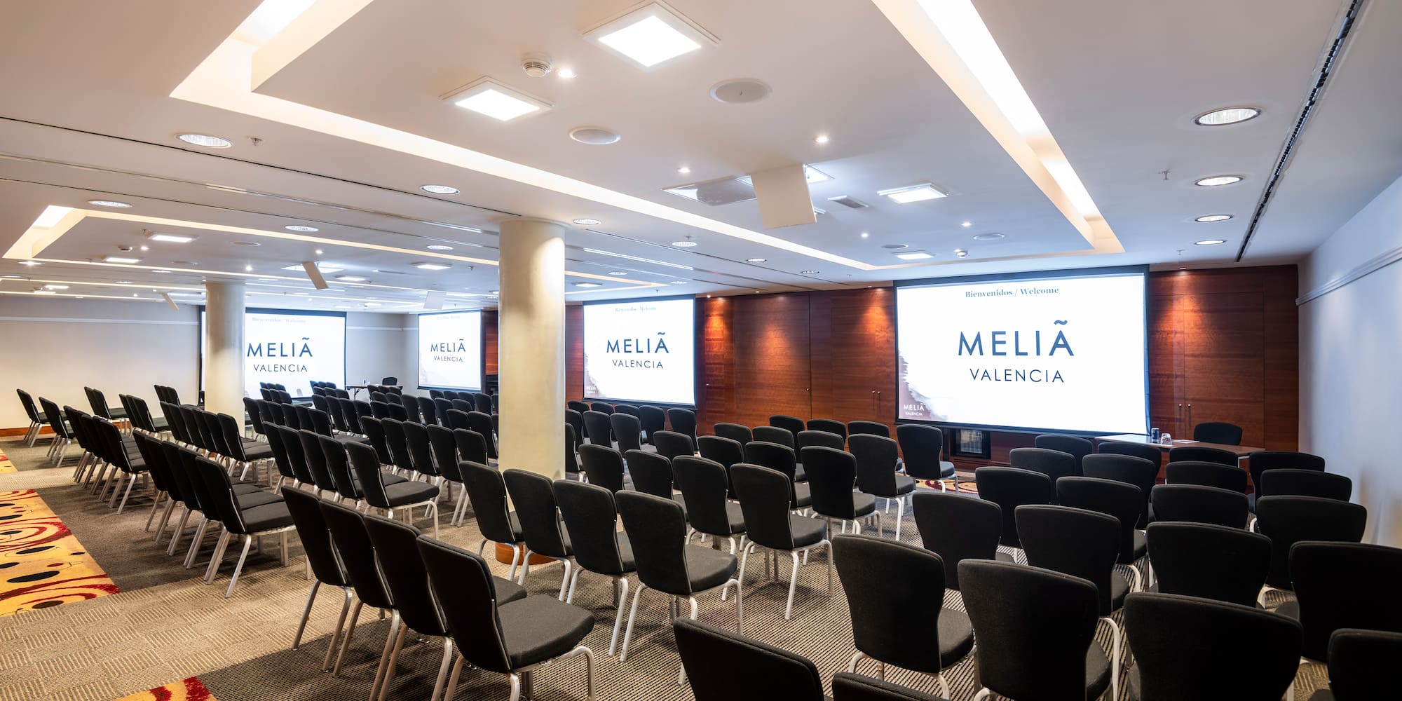 a room with chairs and projector screens