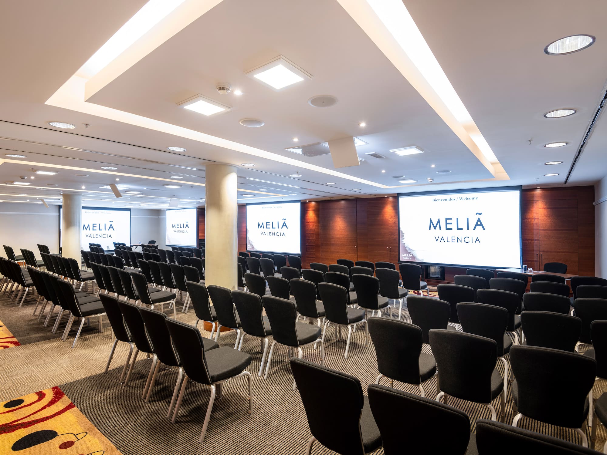 a room with chairs and projector screens