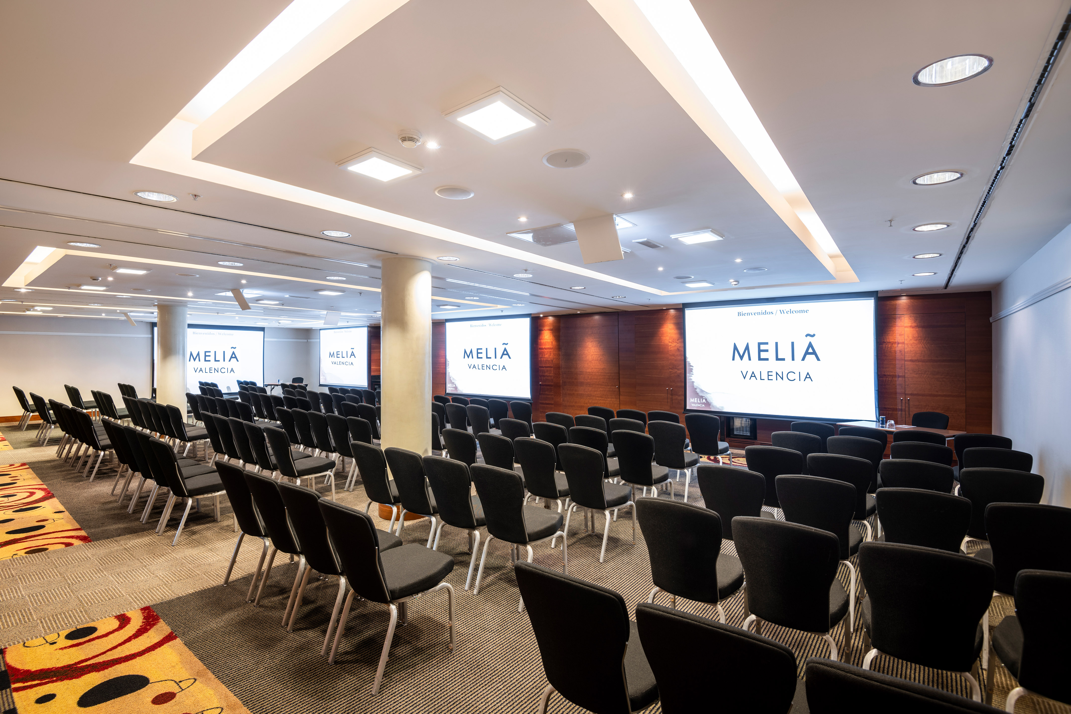 a room with chairs and projector screens