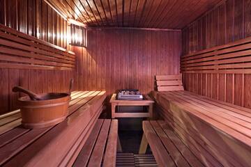 a wooden sauna with a bucket and a grill