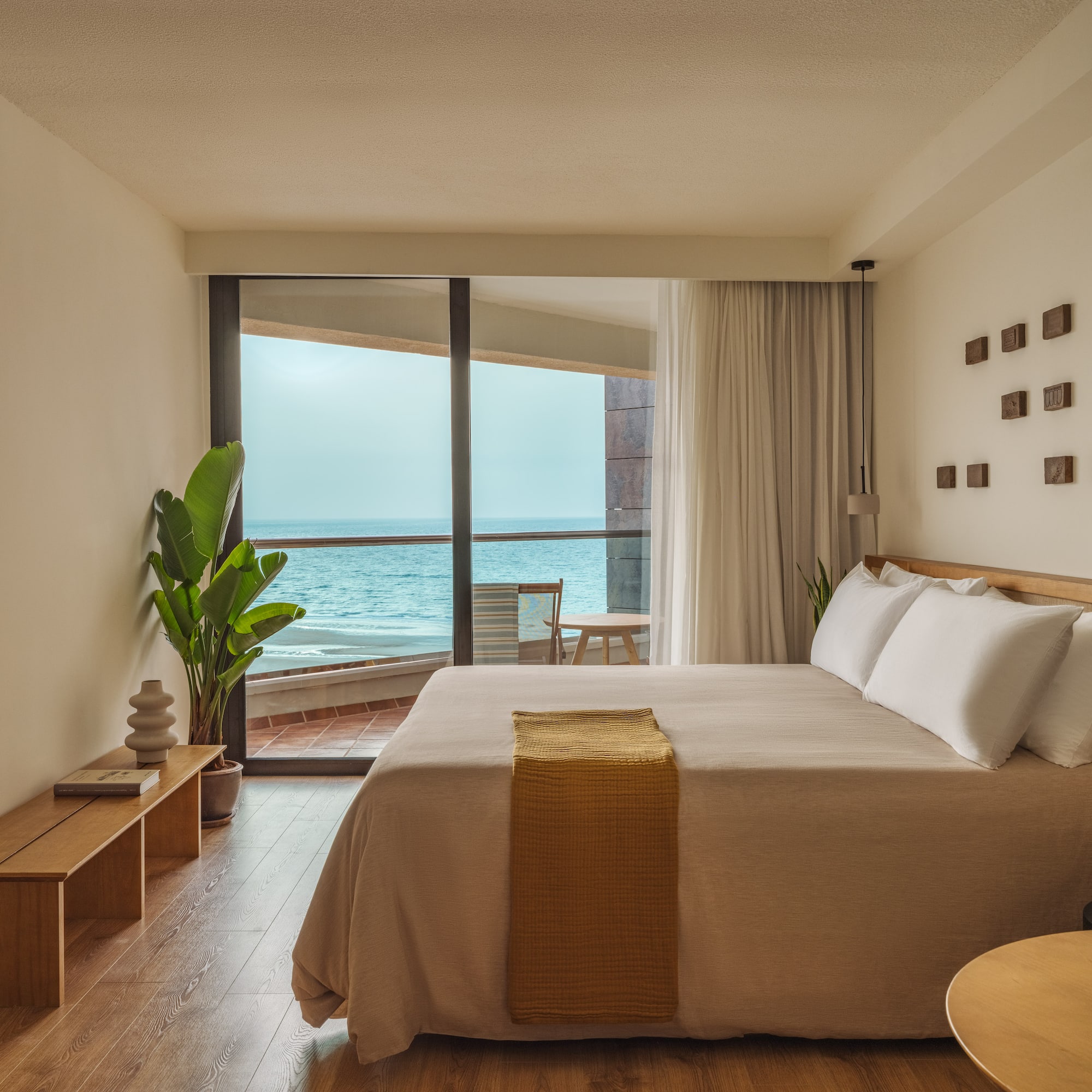 a bedroom with a large window overlooking the ocean