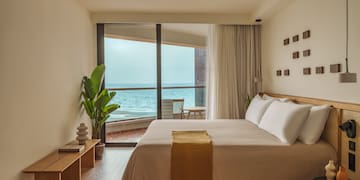 a bedroom with a large window overlooking the ocean