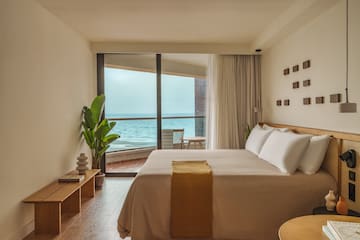 a bedroom with a large window overlooking the ocean