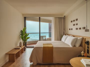 a bedroom with a large window overlooking the ocean