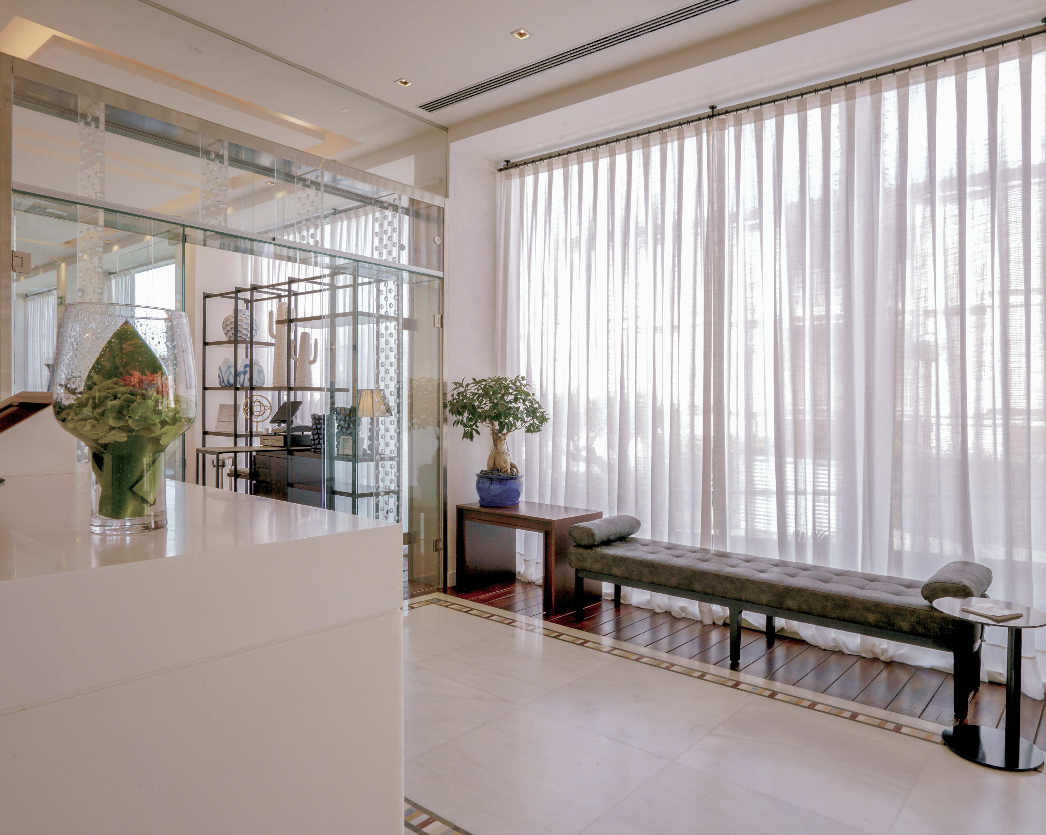 a room with a bench and a glass wall