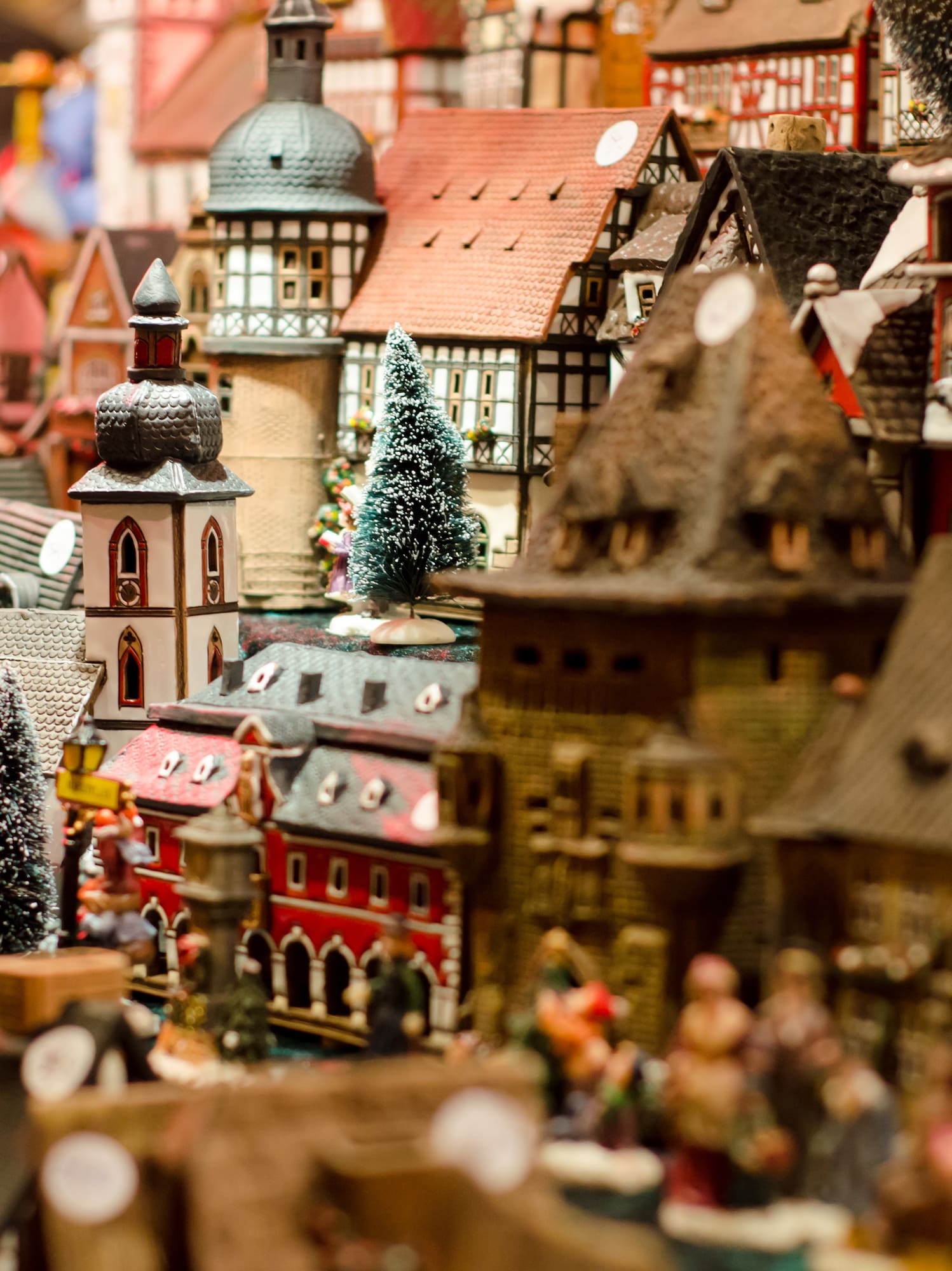 Miniature Christmas village with detailed houses, church, and frosted trees.