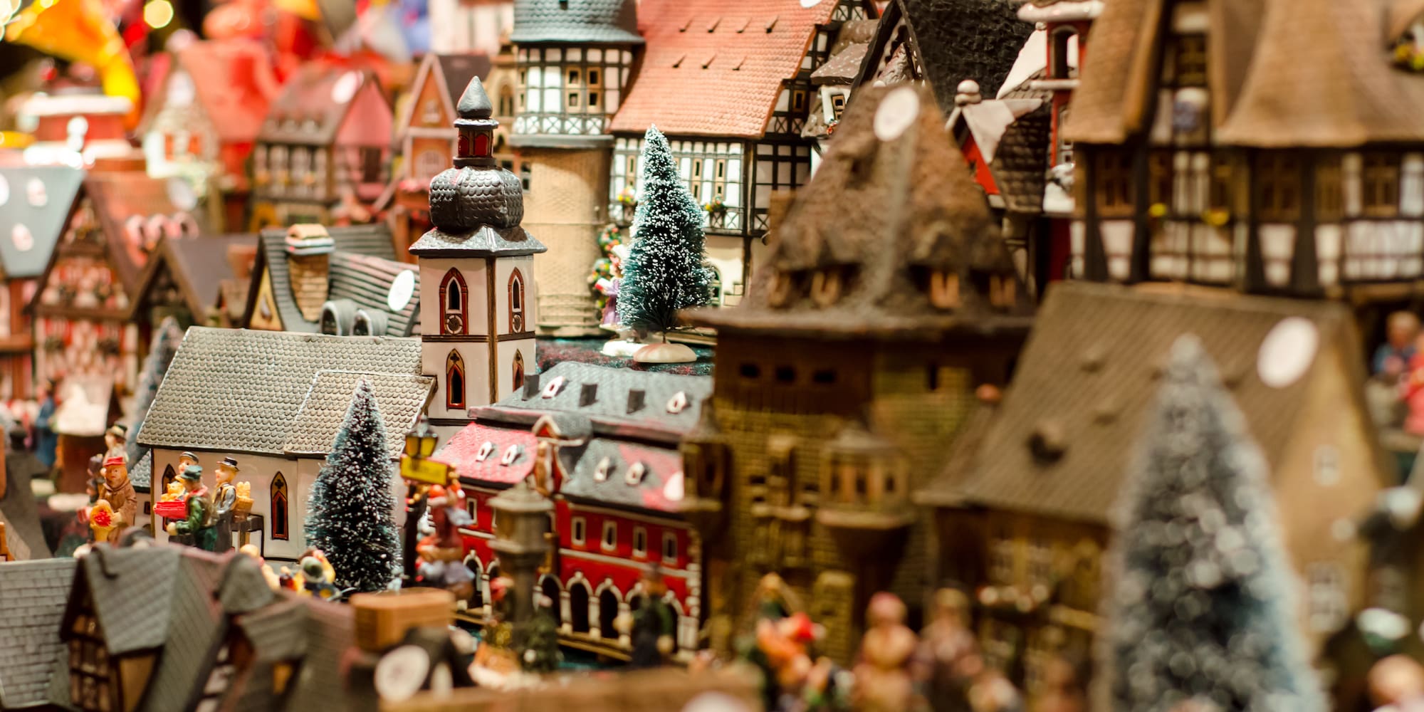 Christmas village diorama with detailed model houses and snowy trees.