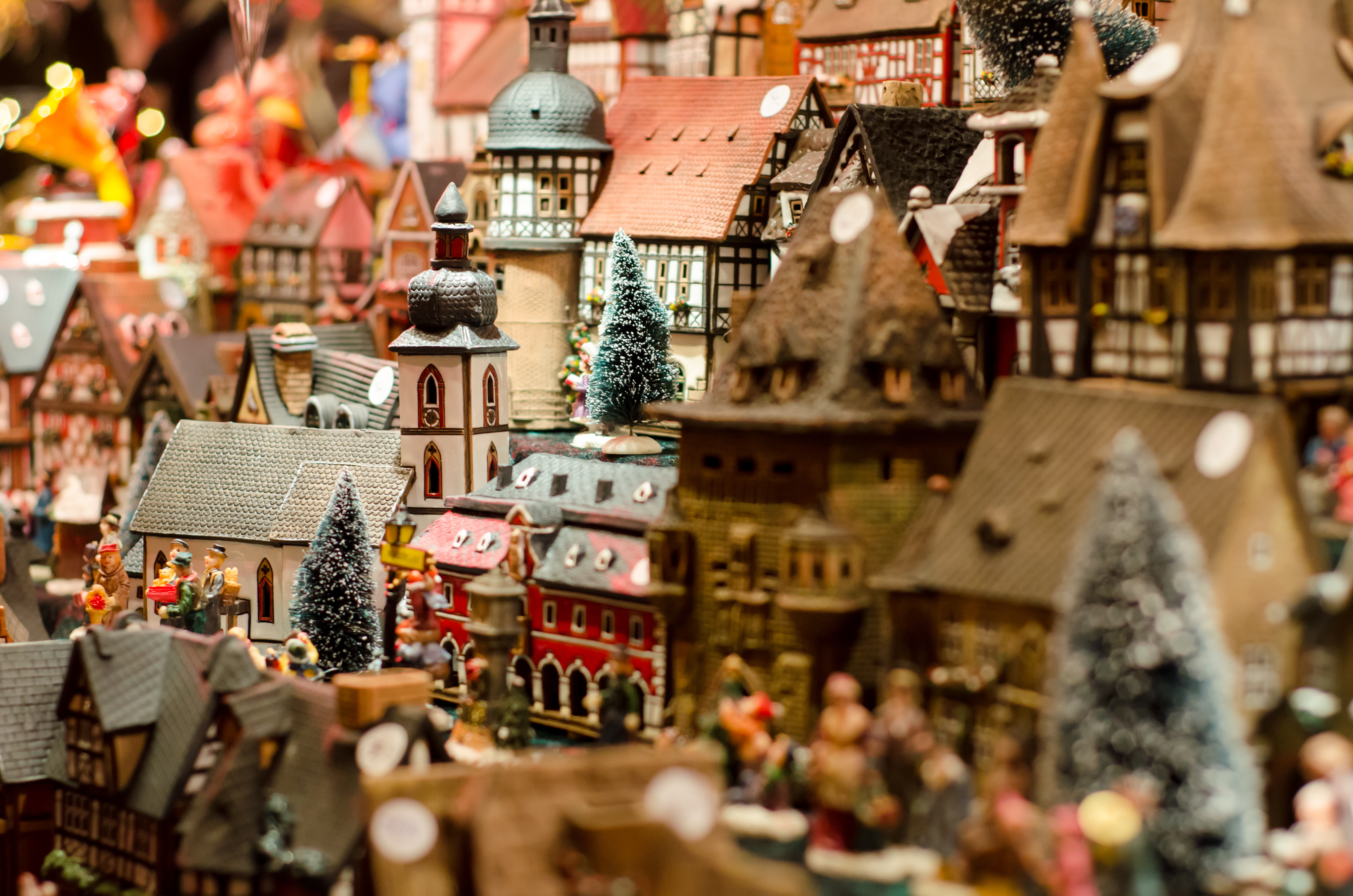 Miniature Christmas village with detailed houses, church, and frosted trees.