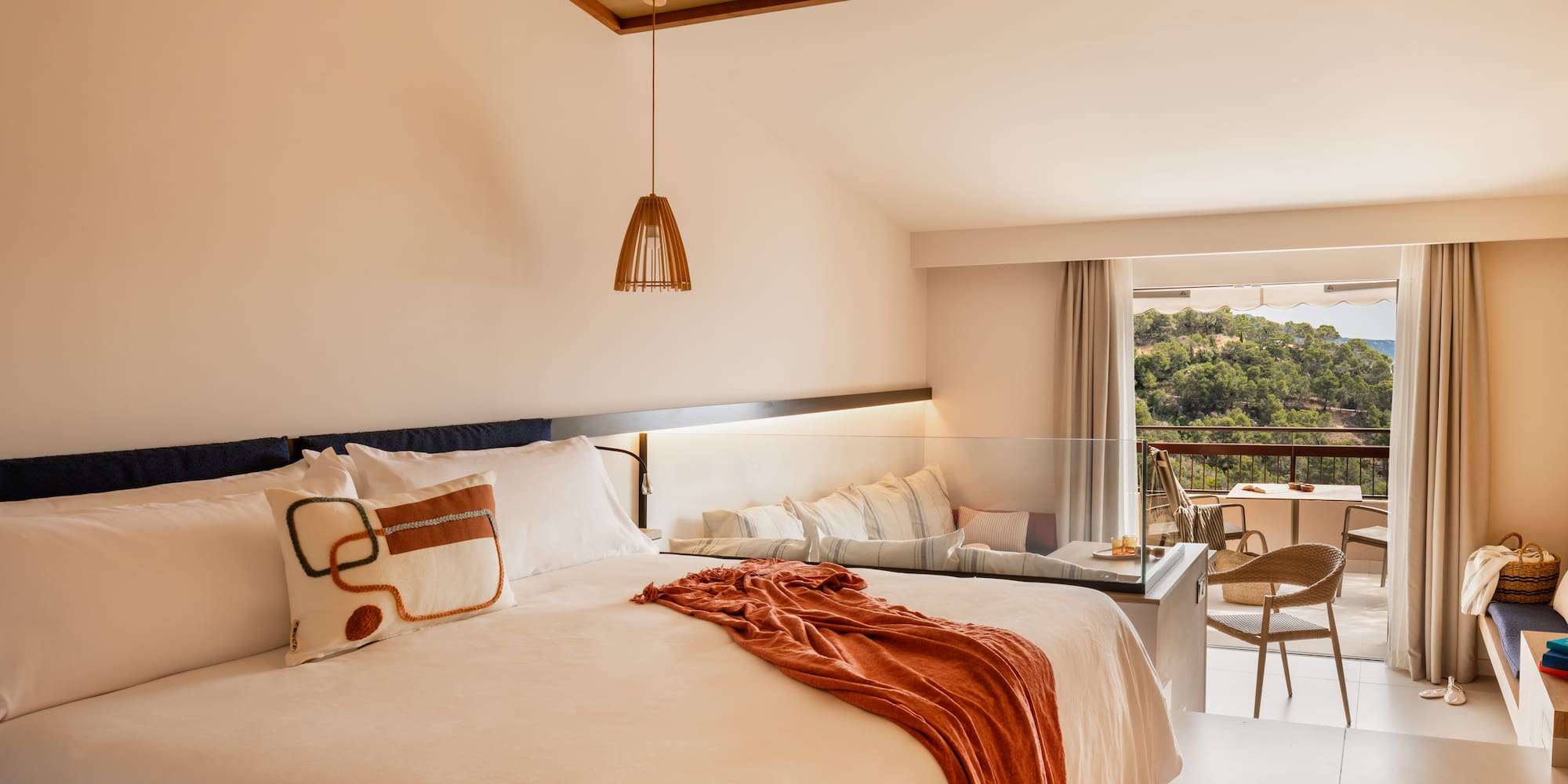 a bed with a table and chairs in a room with a balcony