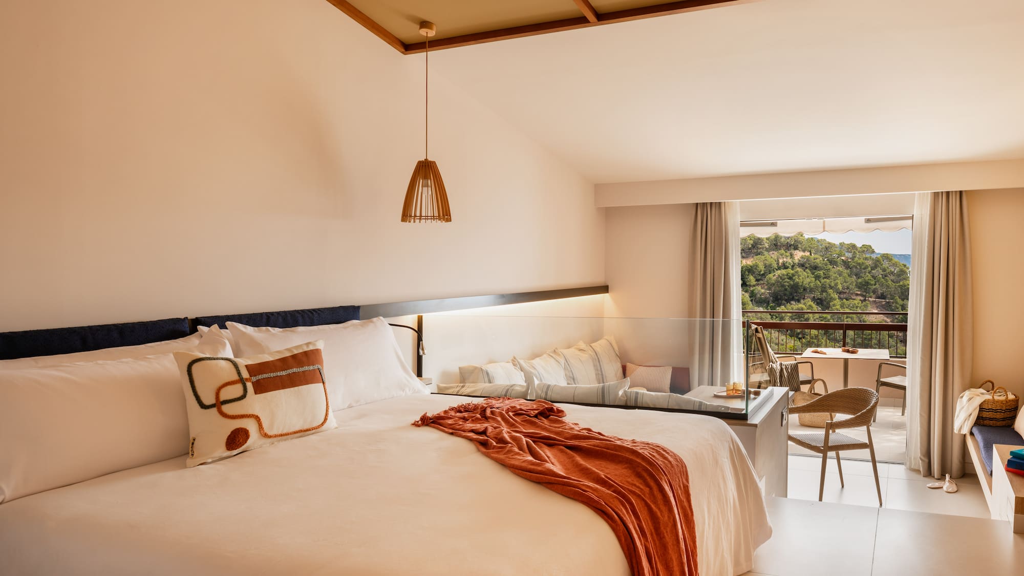 a bed with a table and chairs in a room with a balcony