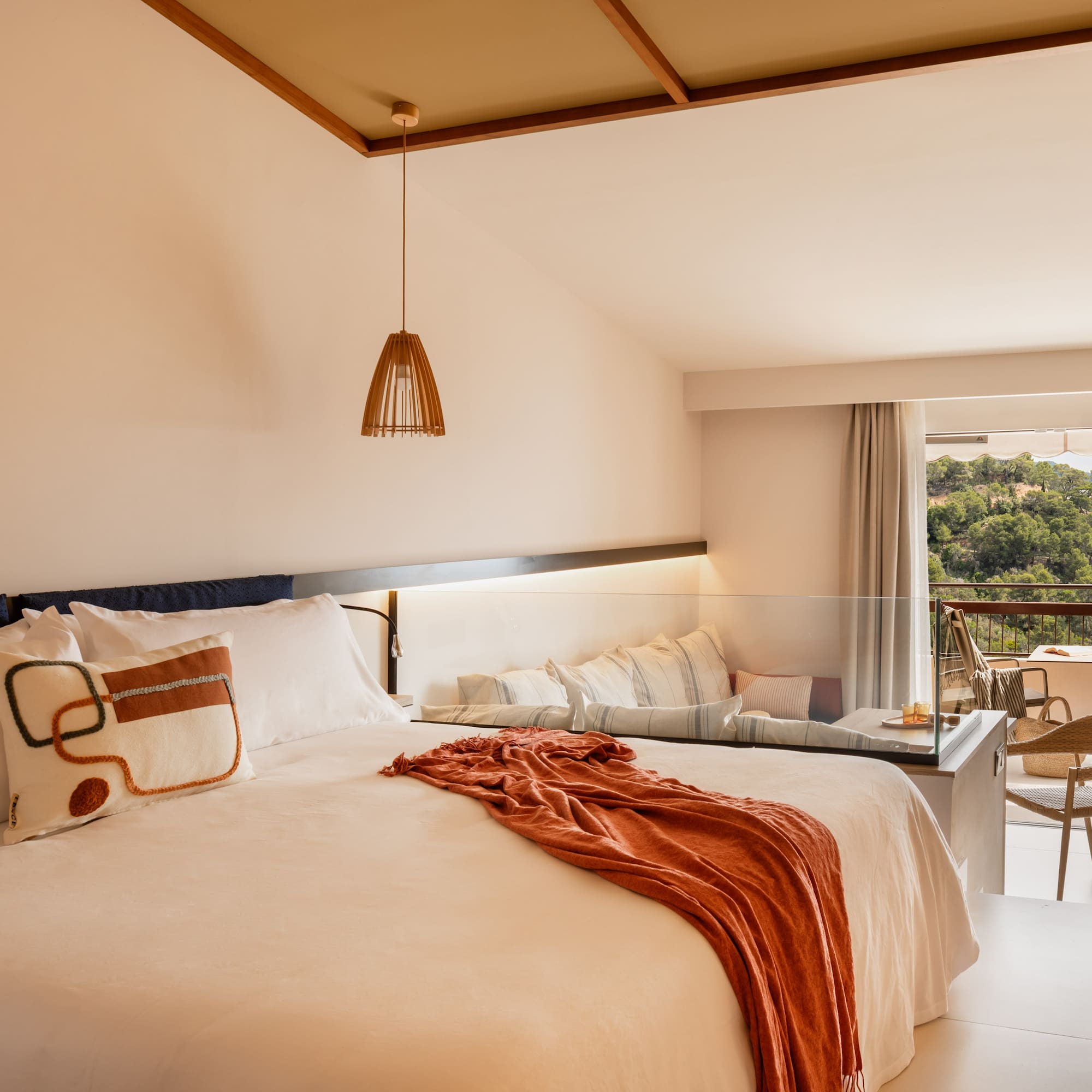 a bed with a table and chairs in a room with a balcony