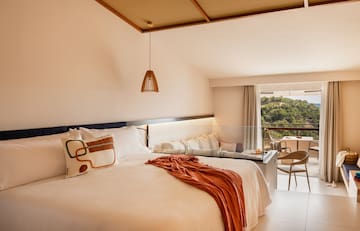 a bed with a table and chairs in a room with a balcony