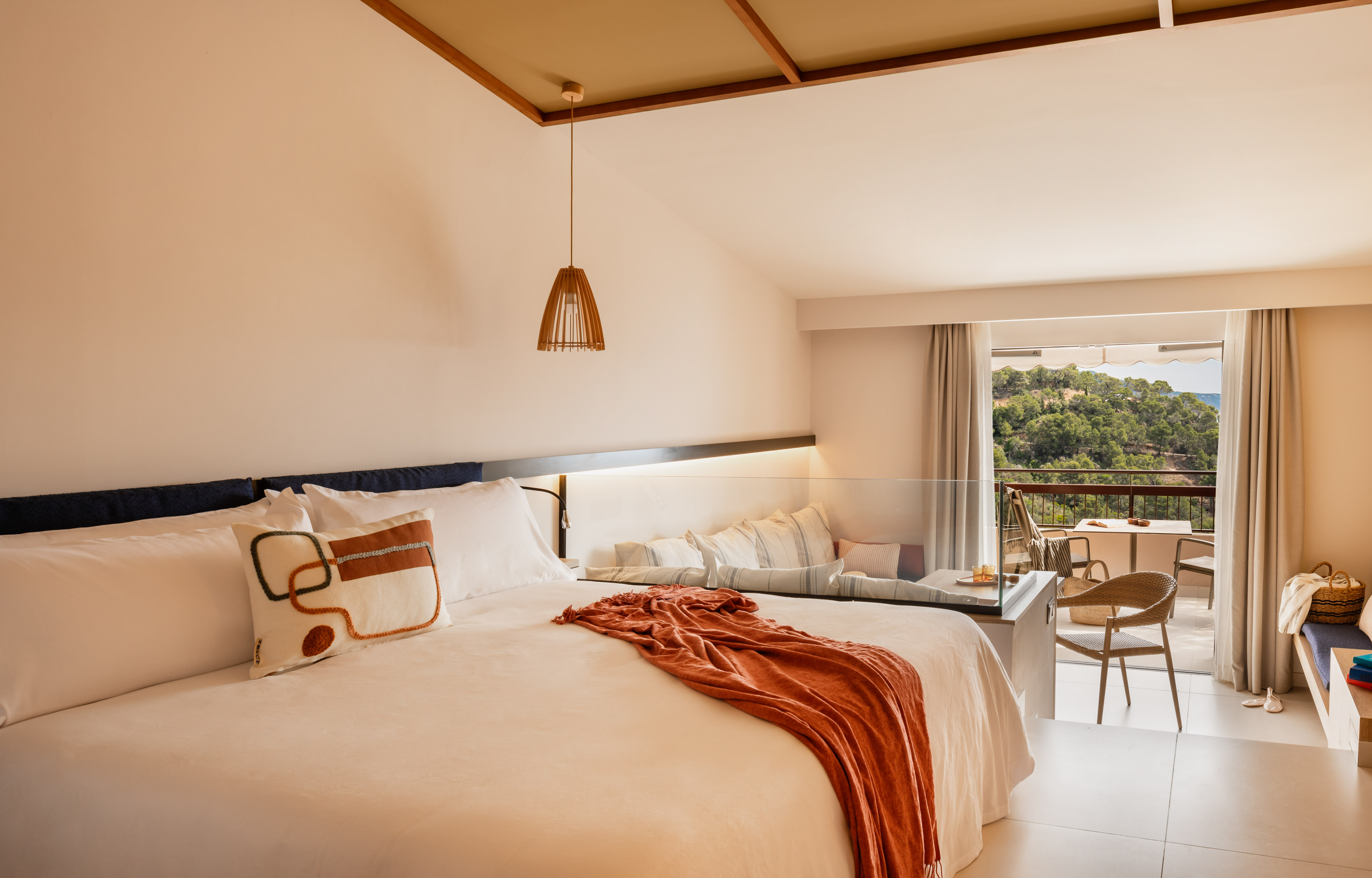 a bed with a table and chairs in a room with a balcony