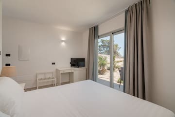 a bedroom with a bed and a desk and a sliding glass door
