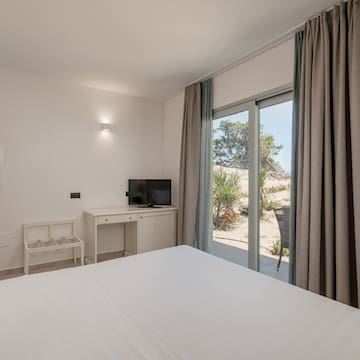 a bedroom with a bed and a desk and a sliding glass door