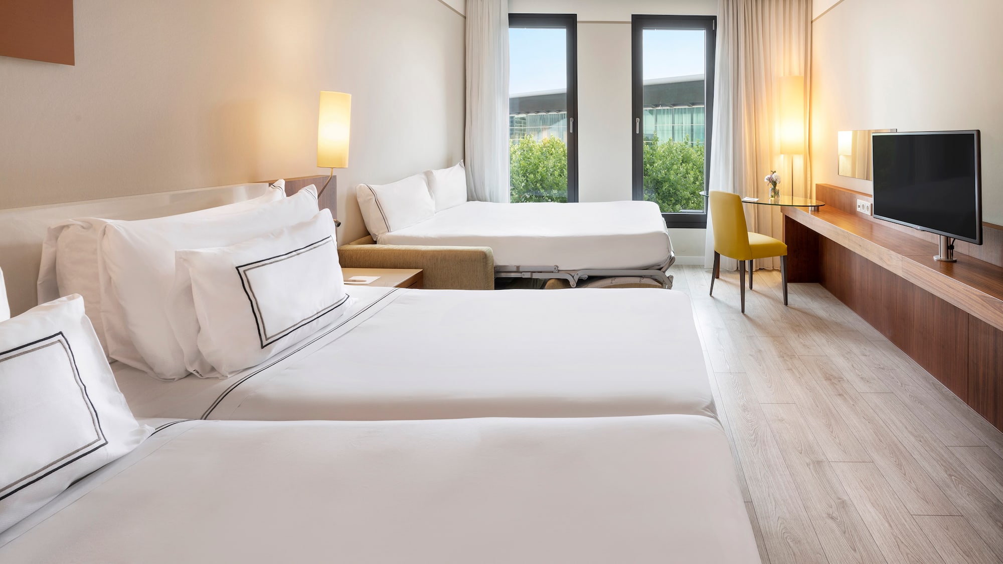 a room with two beds and a desk