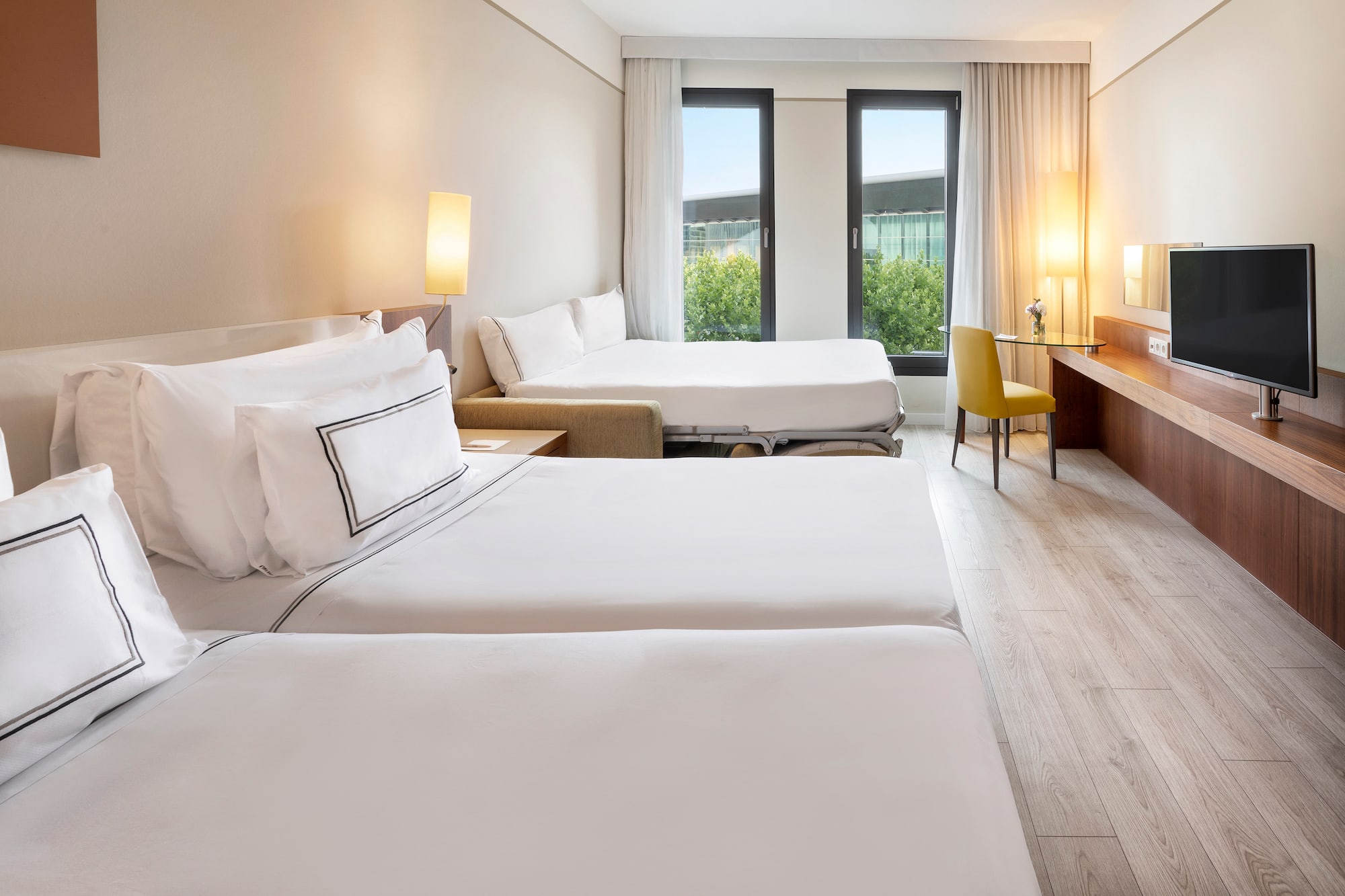 a room with two beds and a desk