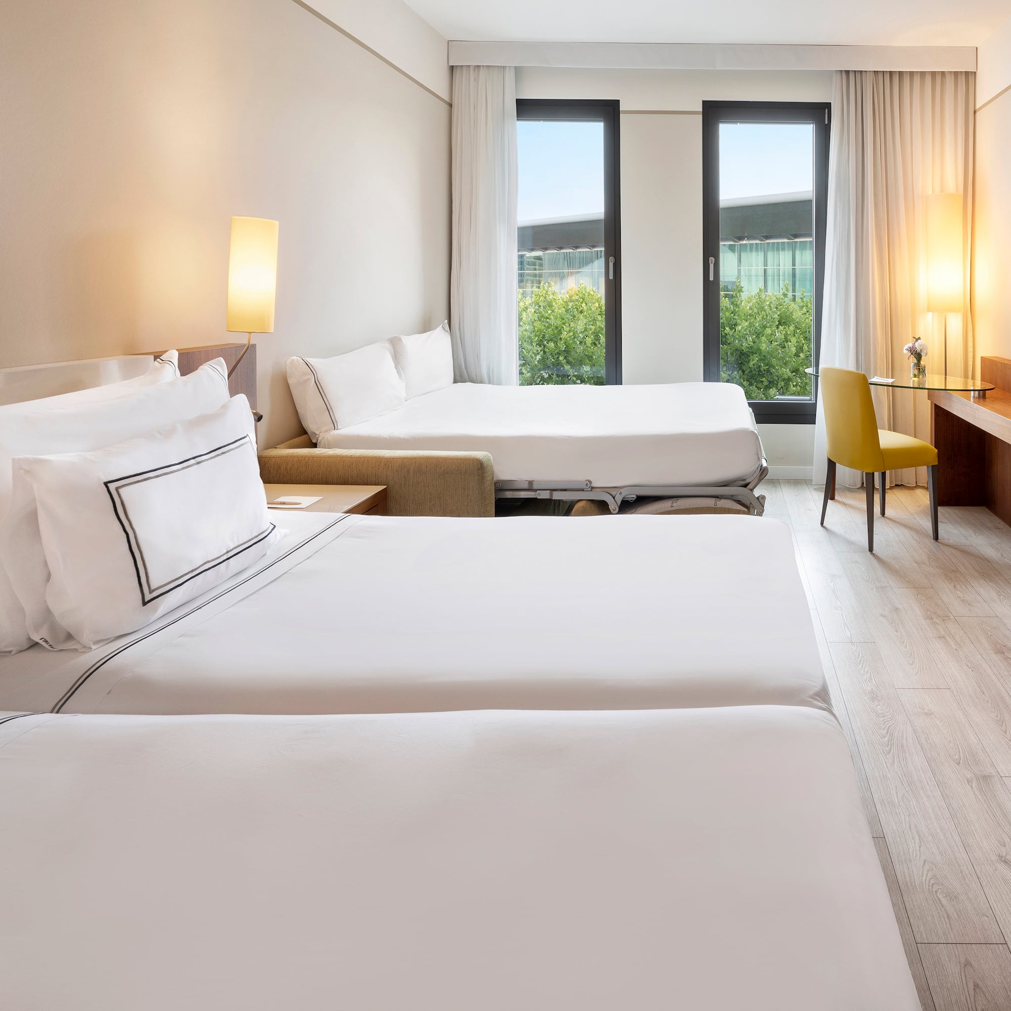 a room with two beds and a desk