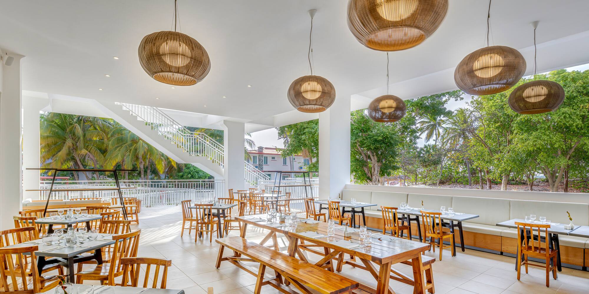 a room with tables and chairs and a staircase