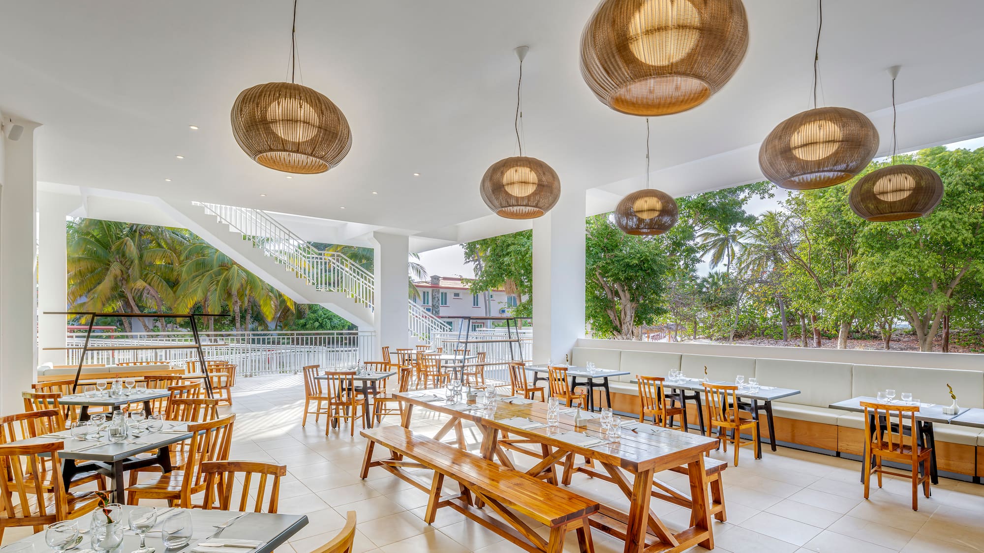 a room with tables and chairs and a staircase