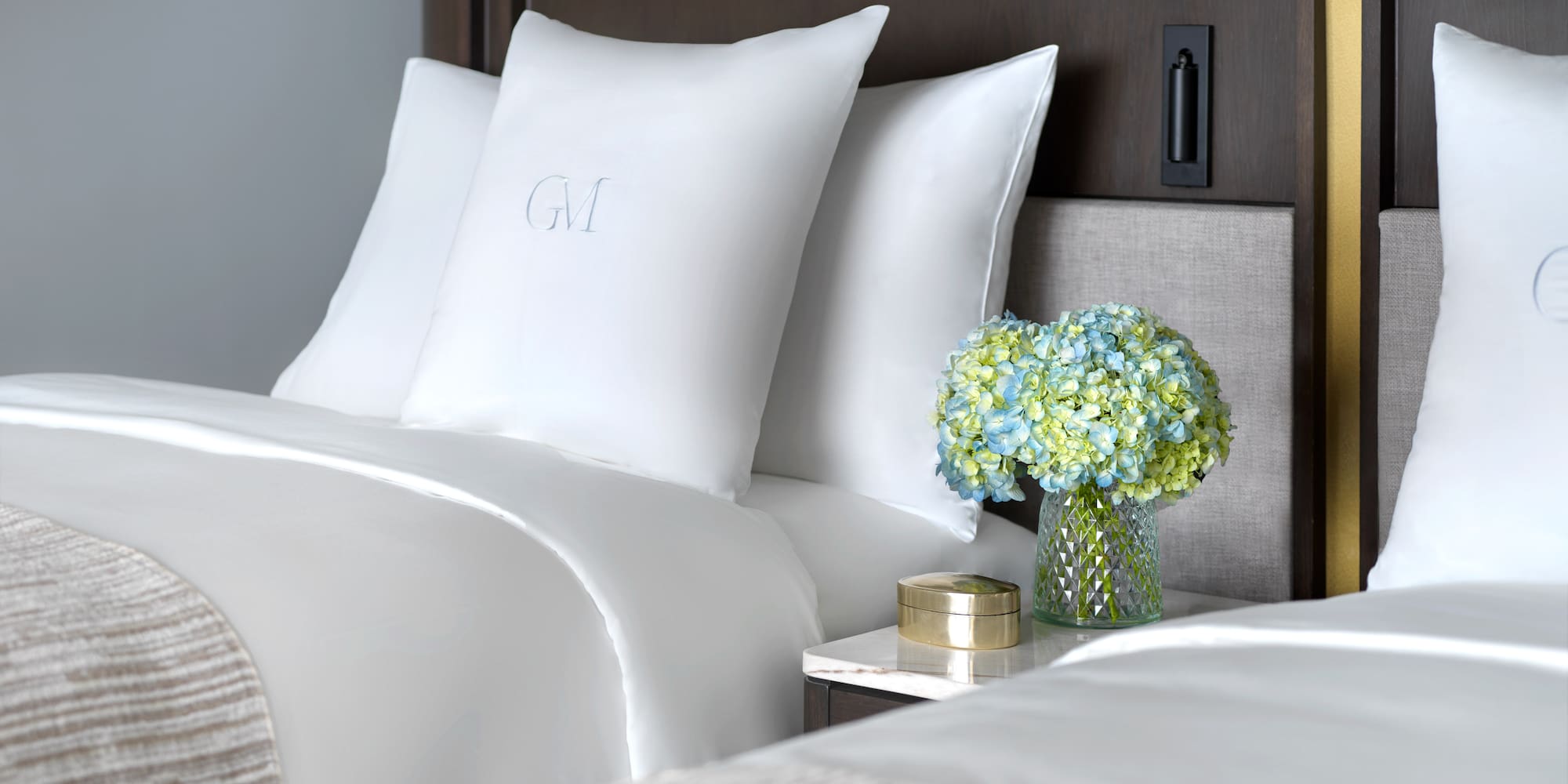 a vase of flowers and pillows on a table