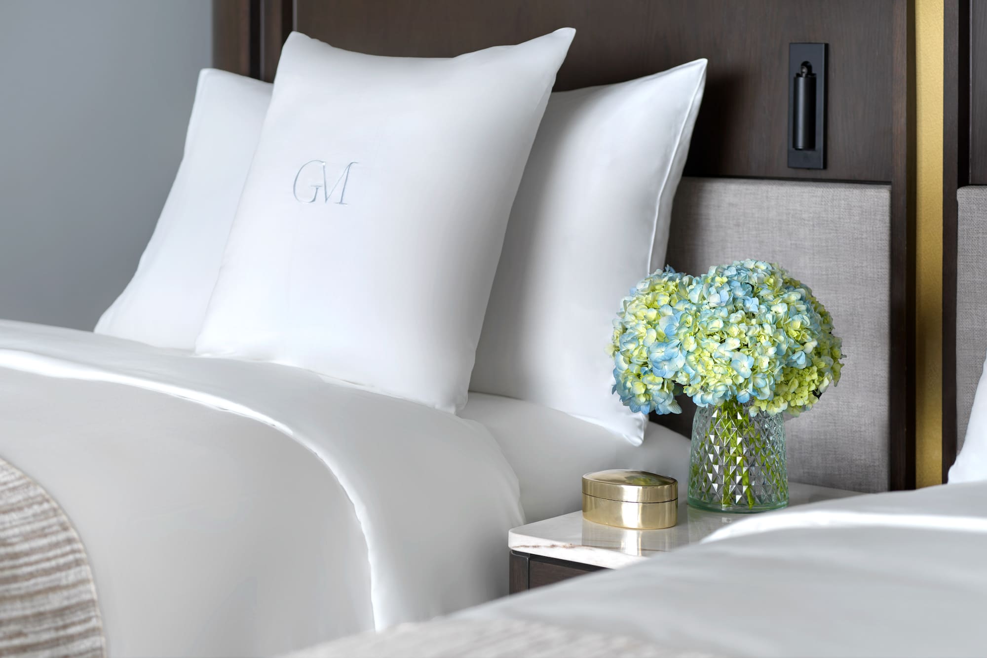 a vase of flowers and pillows on a table