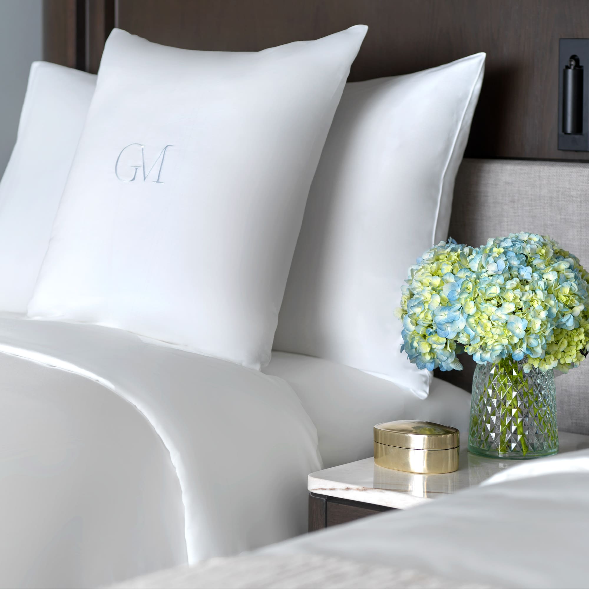 a vase of flowers and pillows on a table