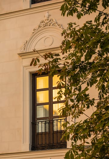 a window with a balcony and a tree