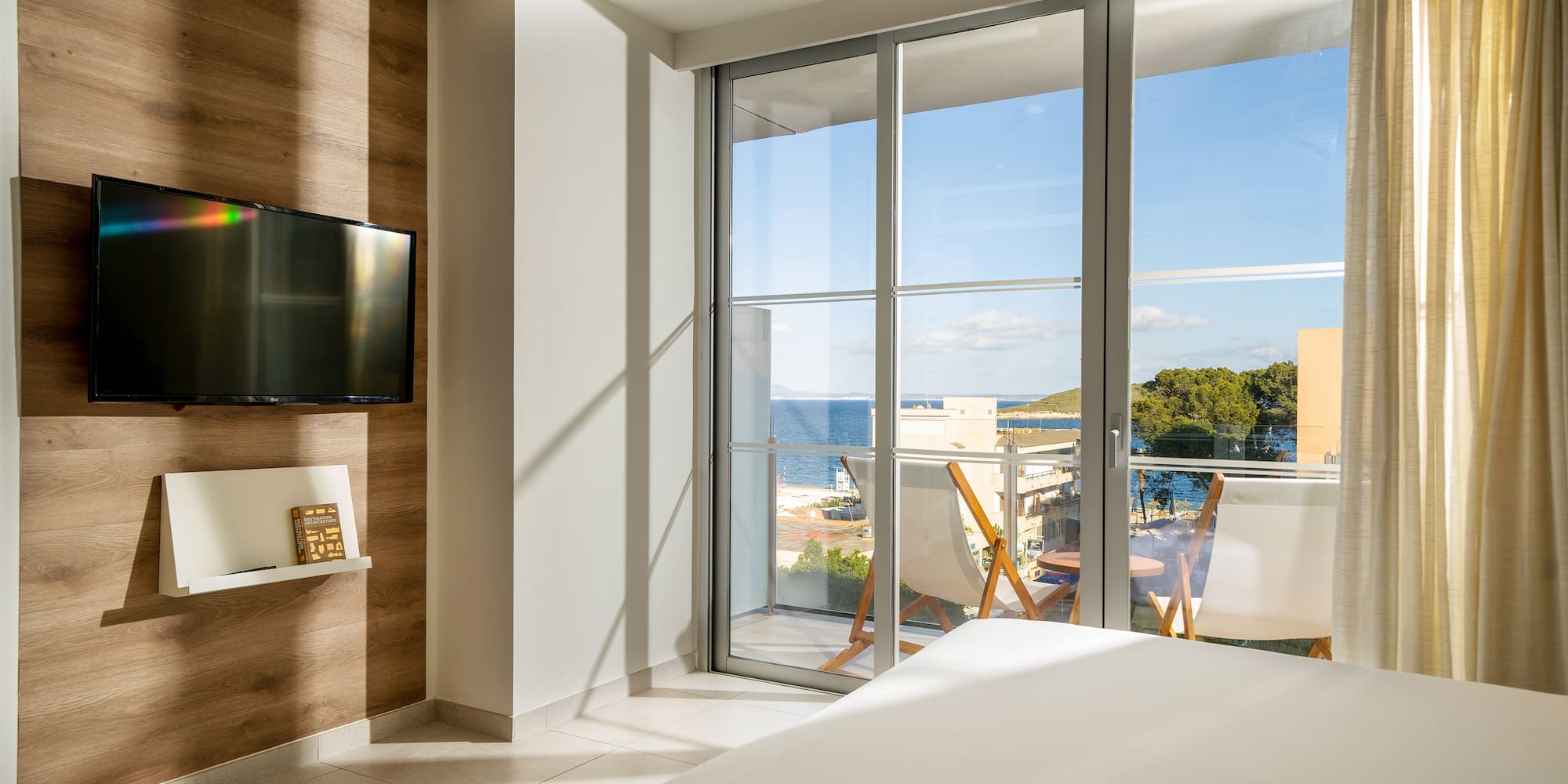 a room with a television and a view of the ocean
