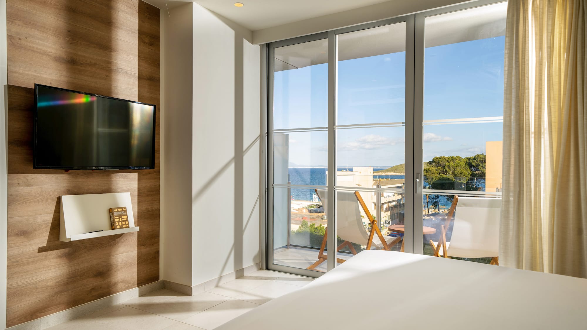 a room with a television and a view of the ocean