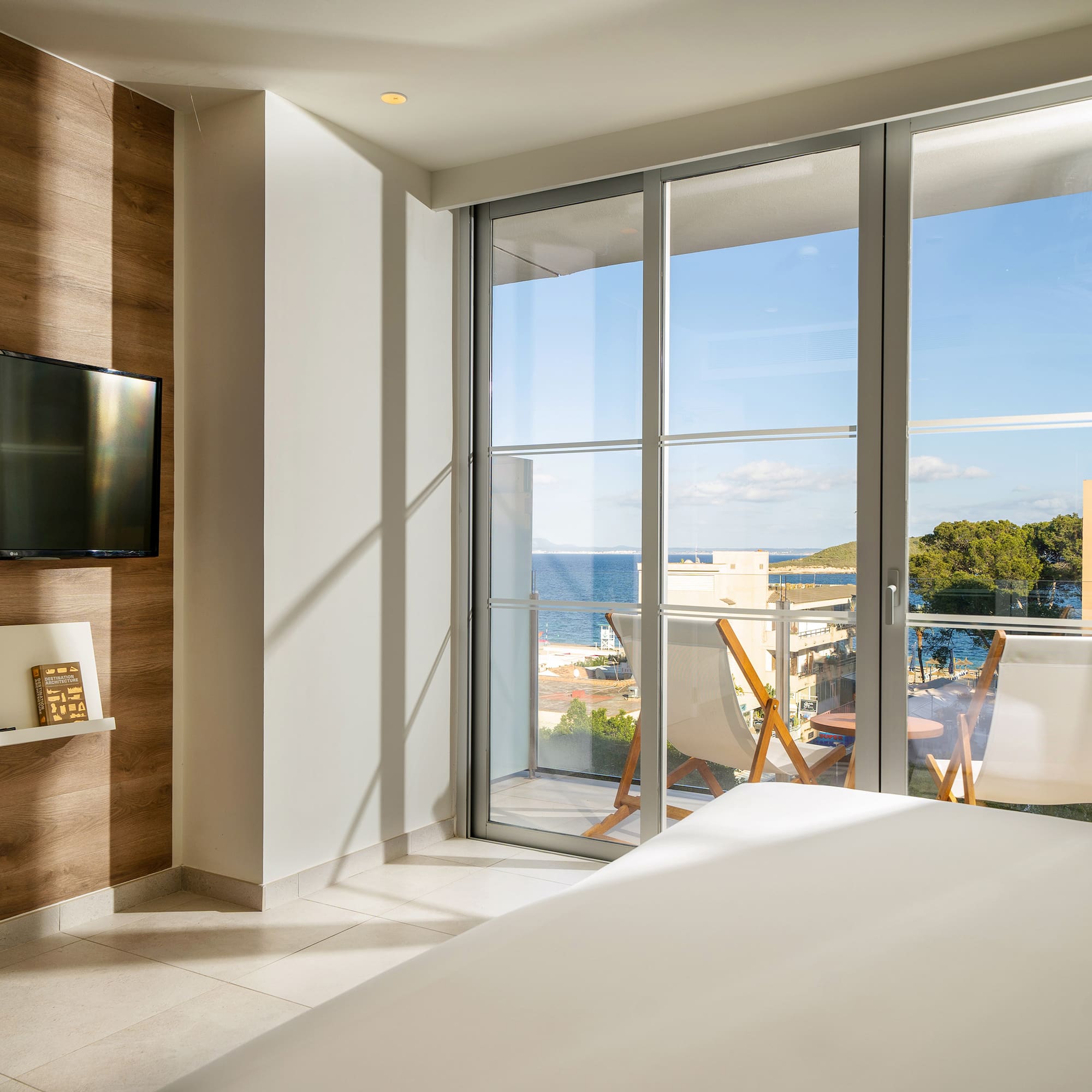 a room with a television and a view of the ocean