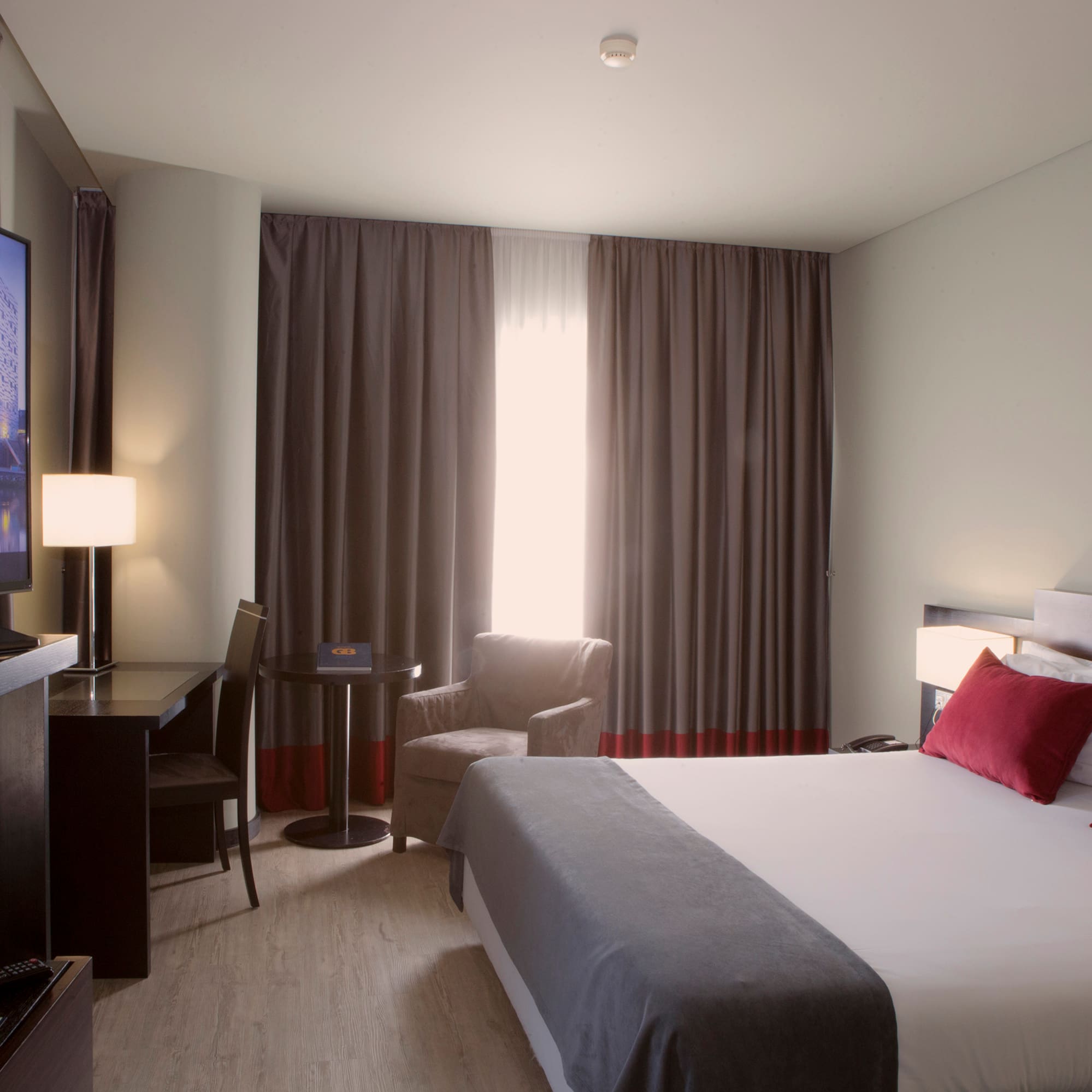 a room with a bed and a television