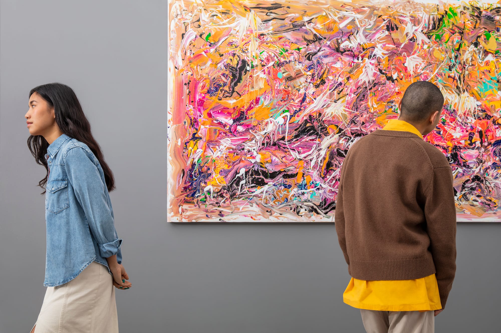 a man and woman looking at a painting