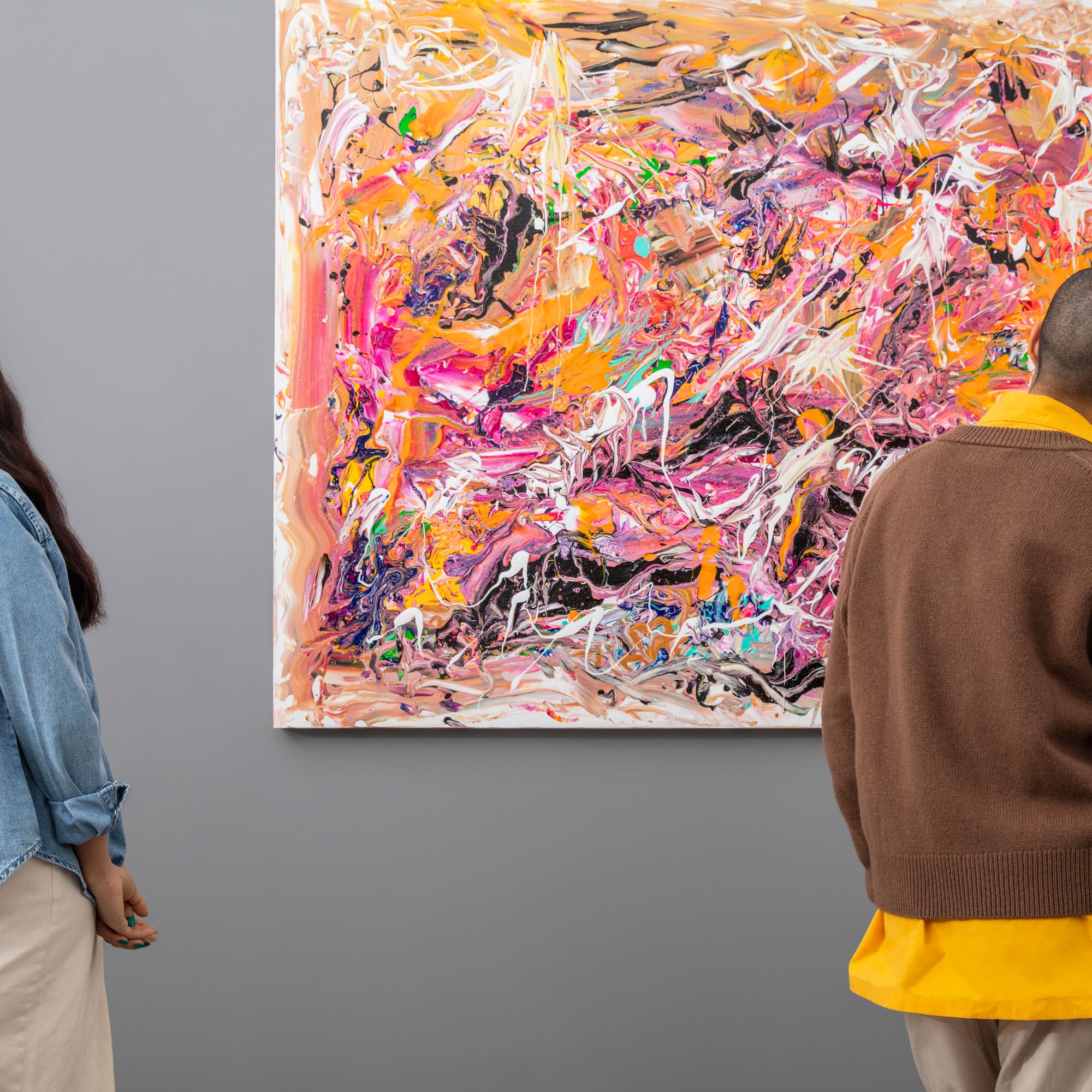 a man and woman looking at a painting