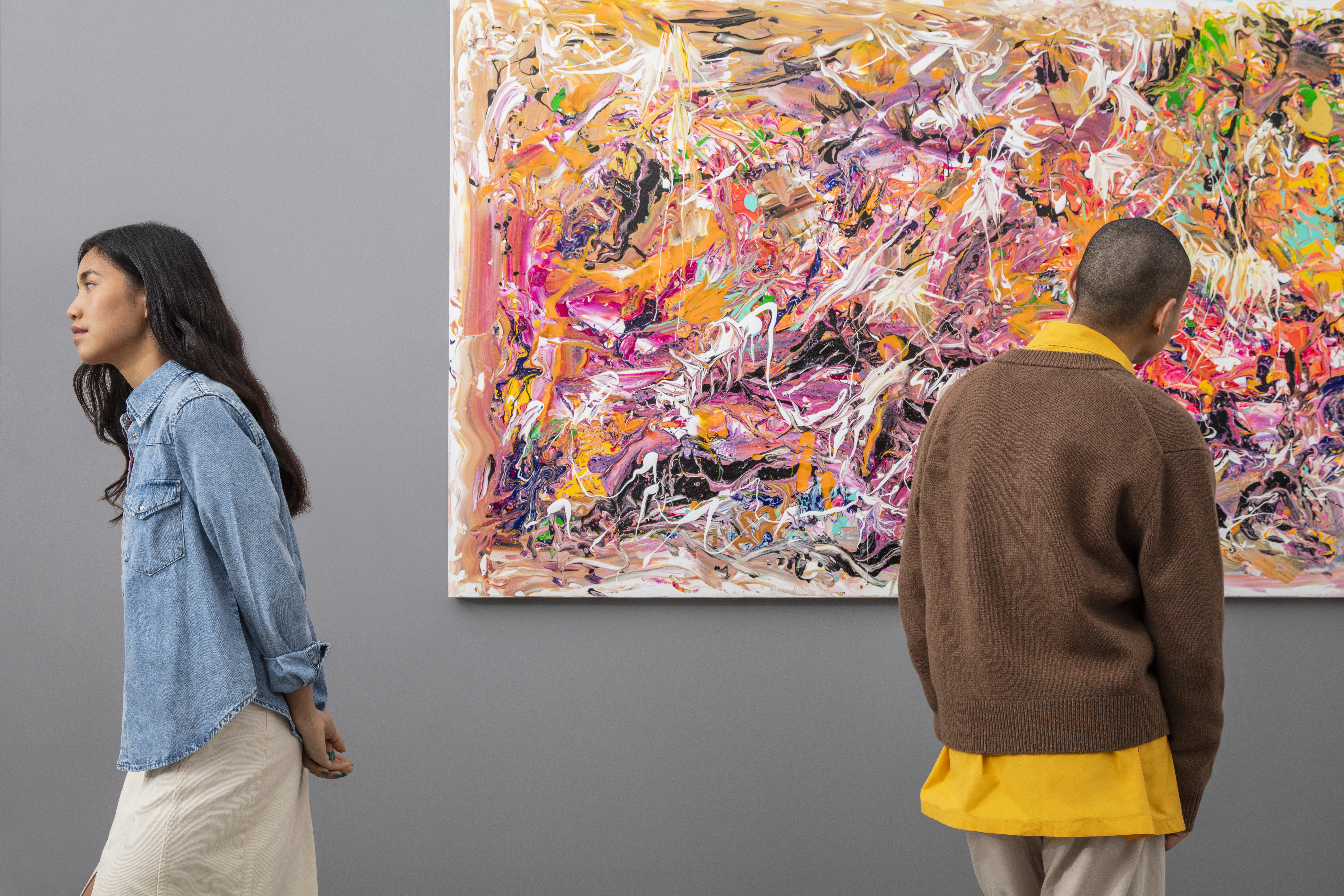 a man and woman looking at a painting
