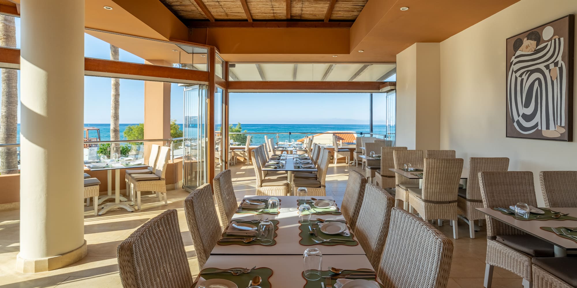 Beachfront restaurant with ocean views, set tables, and resort dining.