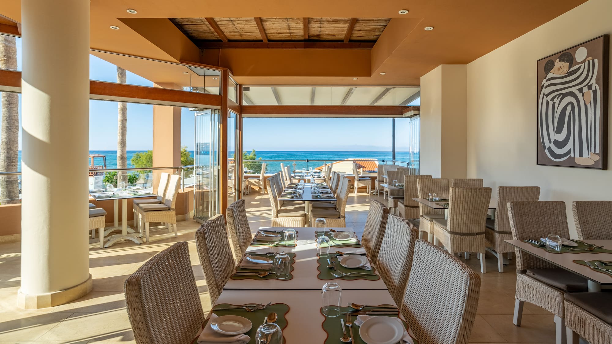 Beachfront restaurant with ocean views, set tables, and resort dining.