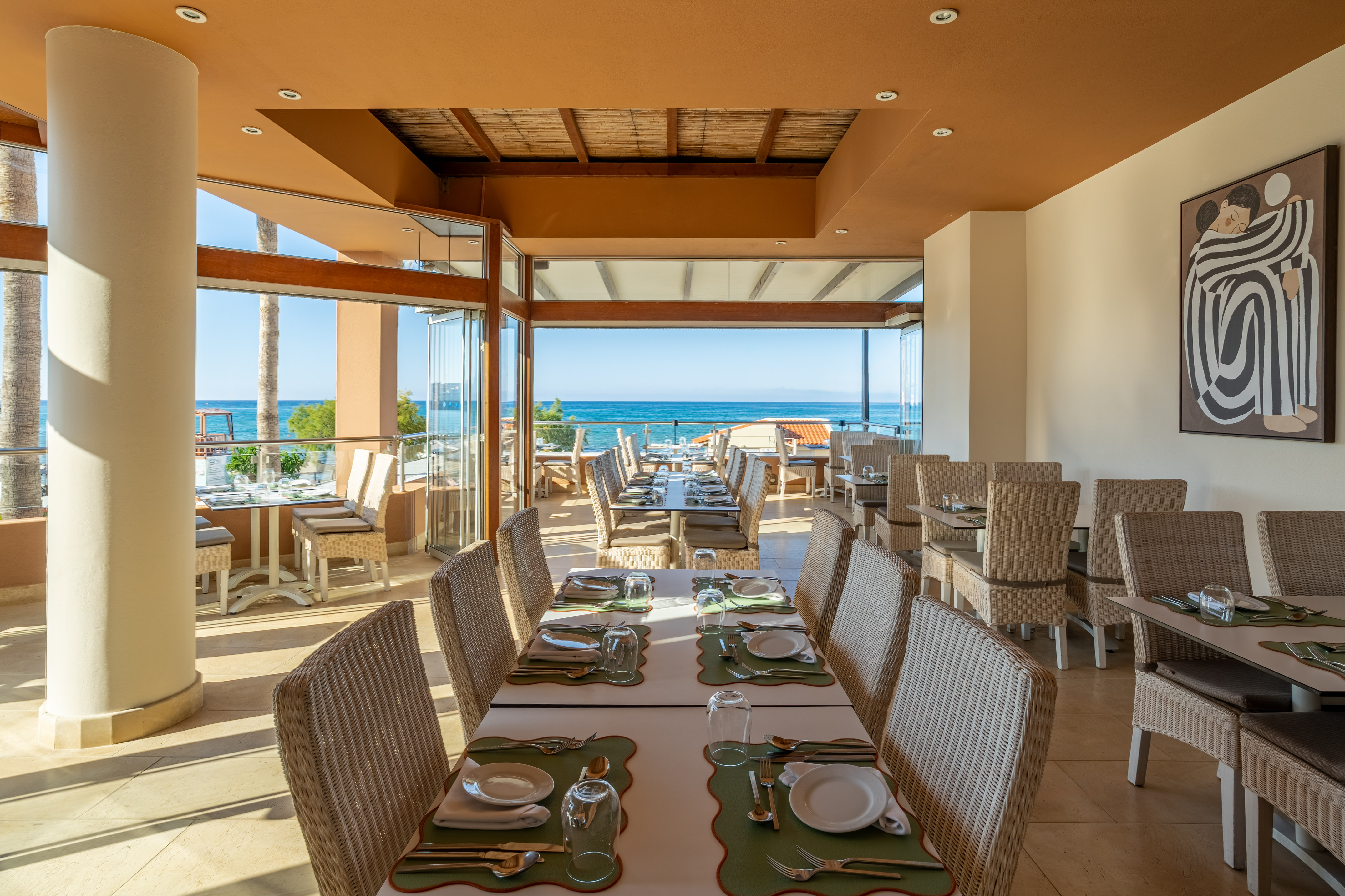 Beachfront restaurant with ocean views, set tables, and resort dining.