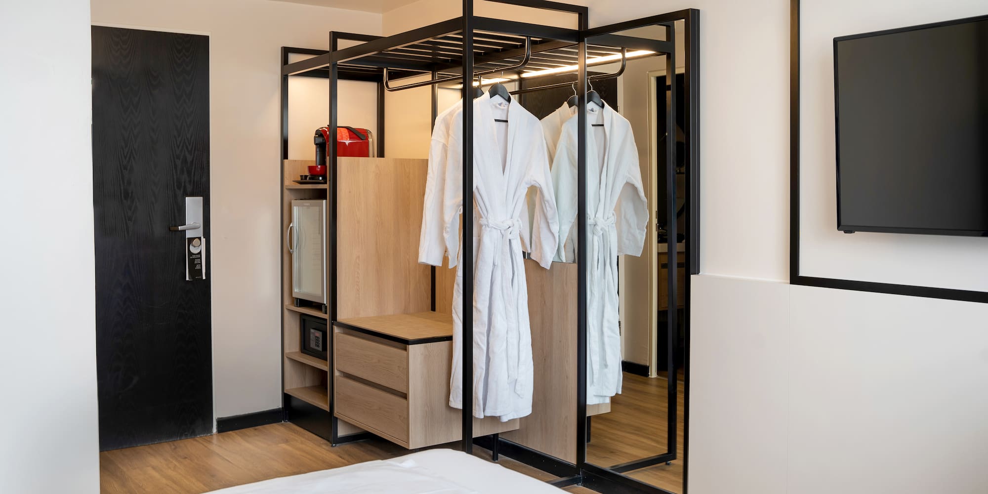 a room with white bathrobes and a mirror
