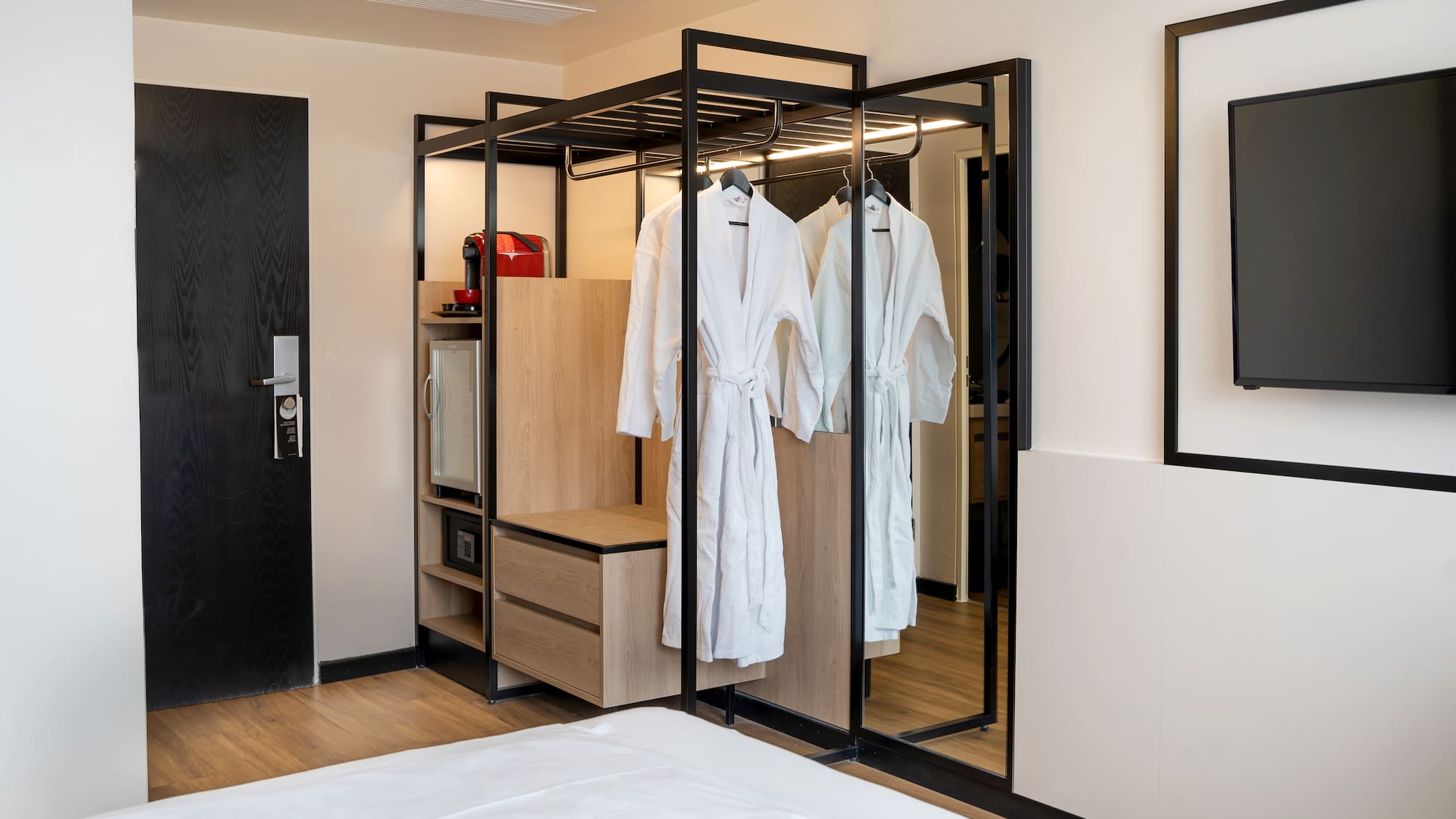 a room with white bathrobes and a mirror