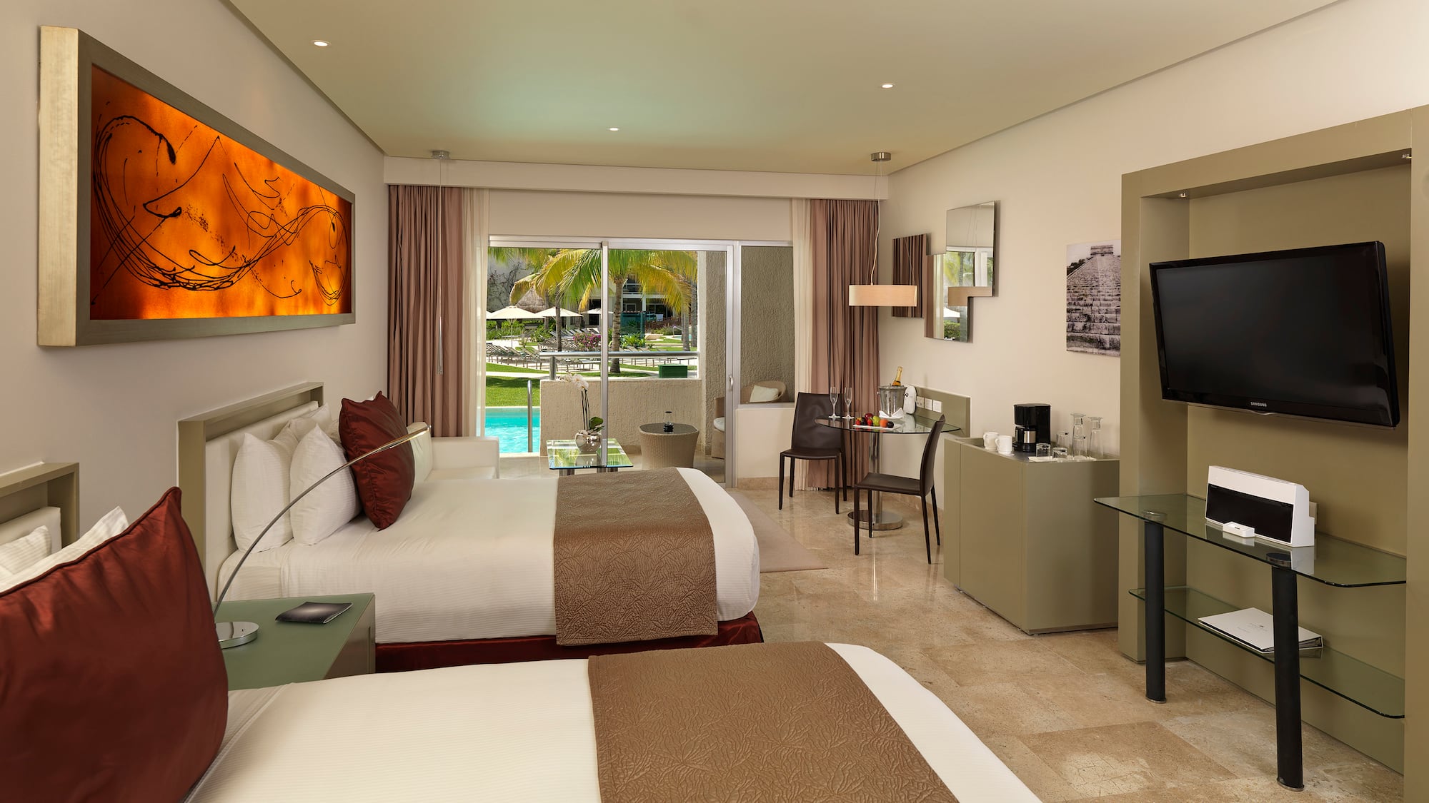 Hotel room with two queen beds, private balcony, and tropical pool view.