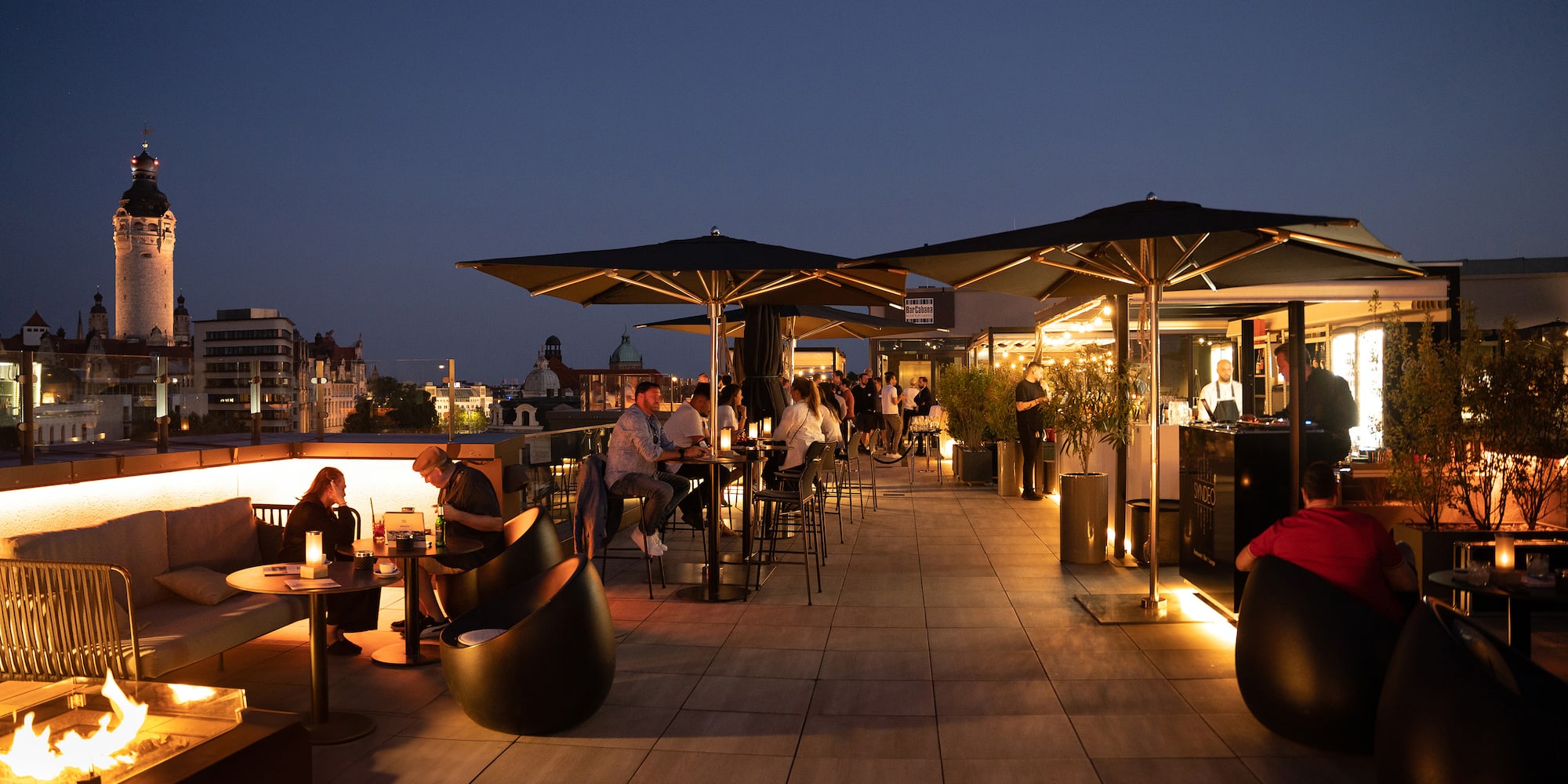 a group of people sitting at tables on a rooftop