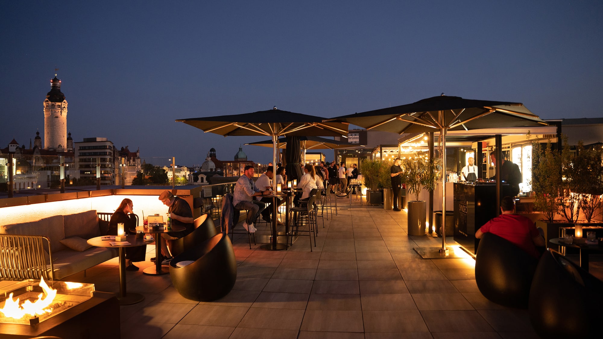 a group of people sitting at tables on a rooftop