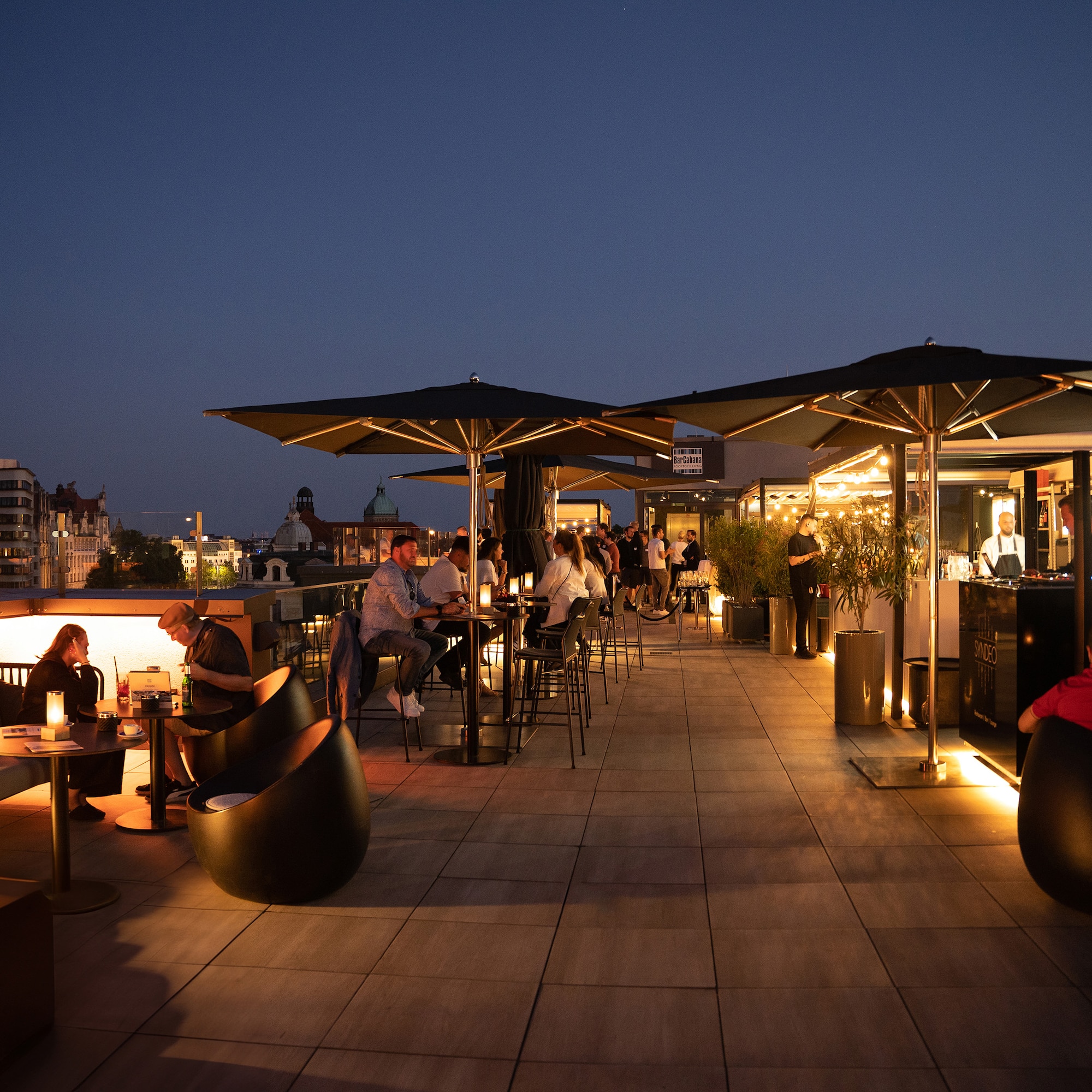 a group of people sitting at tables on a rooftop